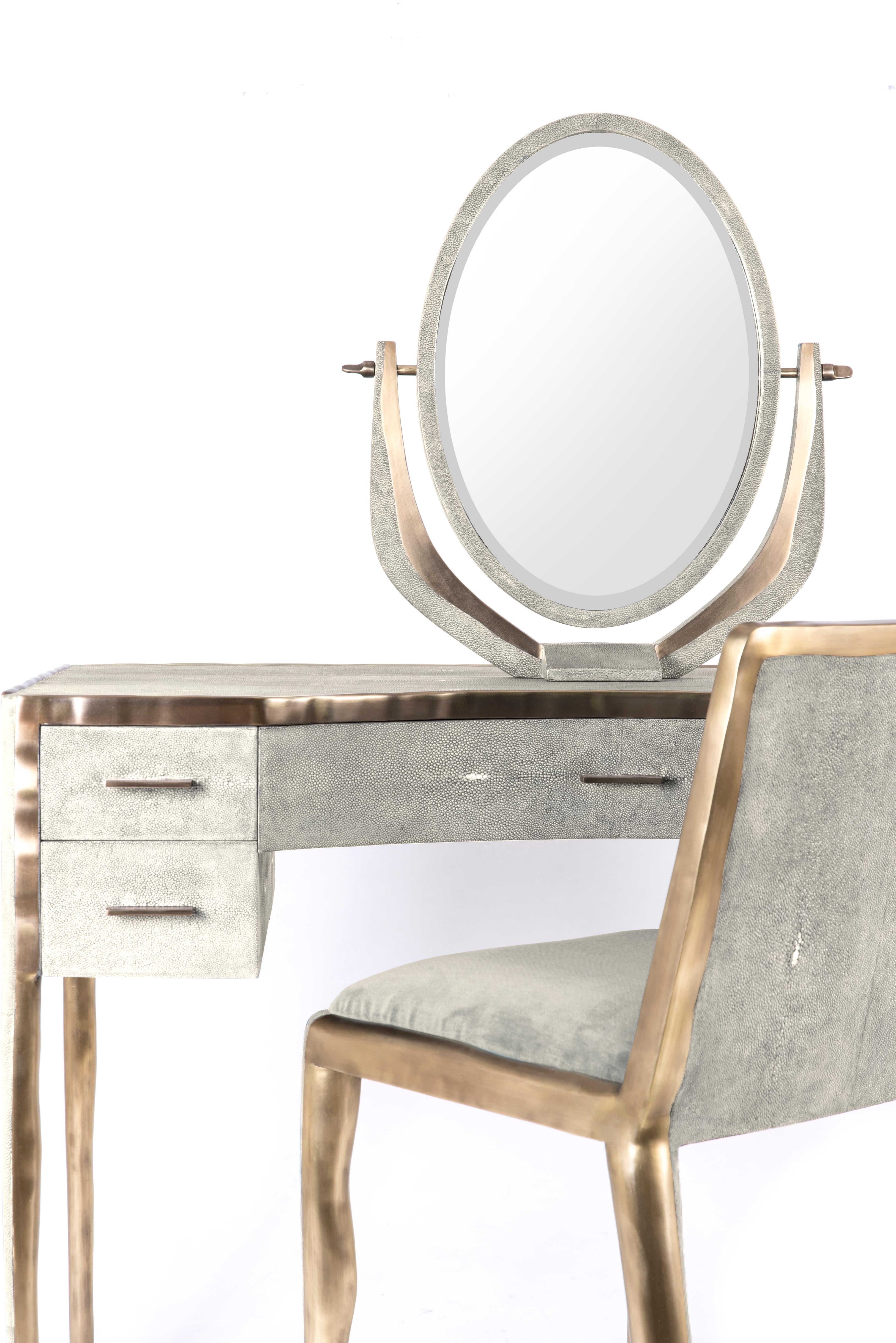 The melting vanity table's simple but elegant design, makes for an adaptable elegant piece of furniture. The cream shagreen inlaid surface is framed with an irregular surface bronze-patina brass that creates the 