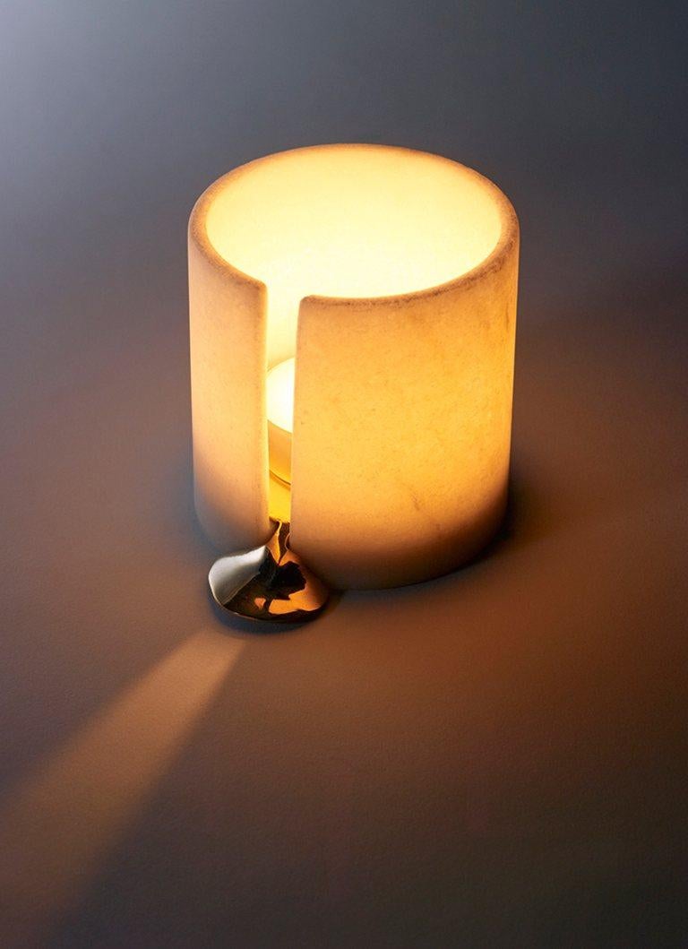 These marble and cast bronze translucent stone tea lights simulate the flow of wax. Sold individually.