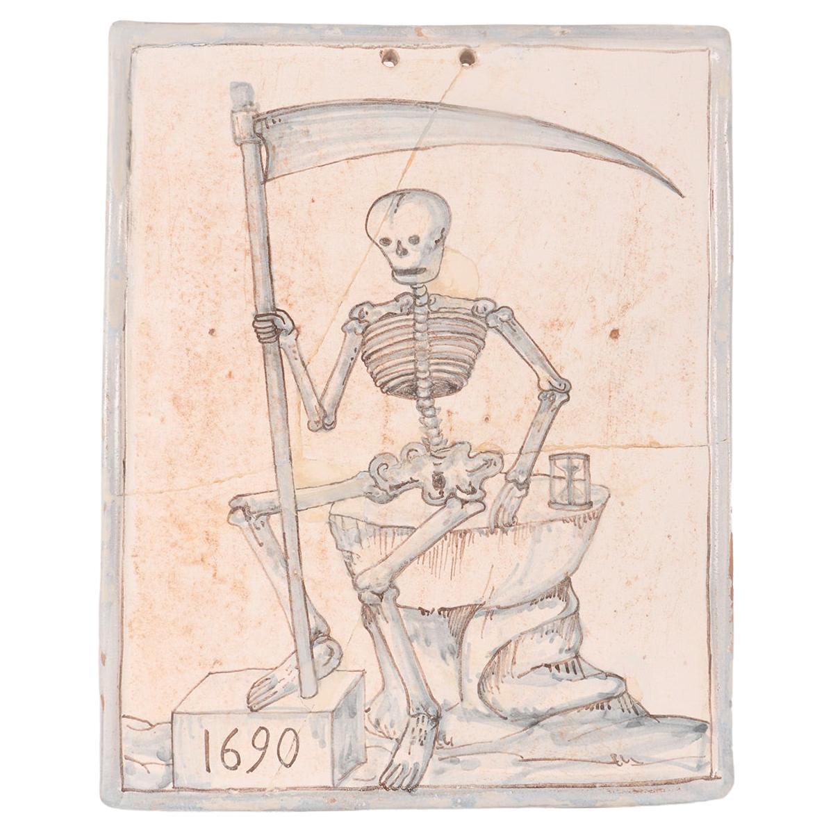 Memento mori: a skeleton, a scythe, an hourglass painted tile, Italy 1690. For Sale