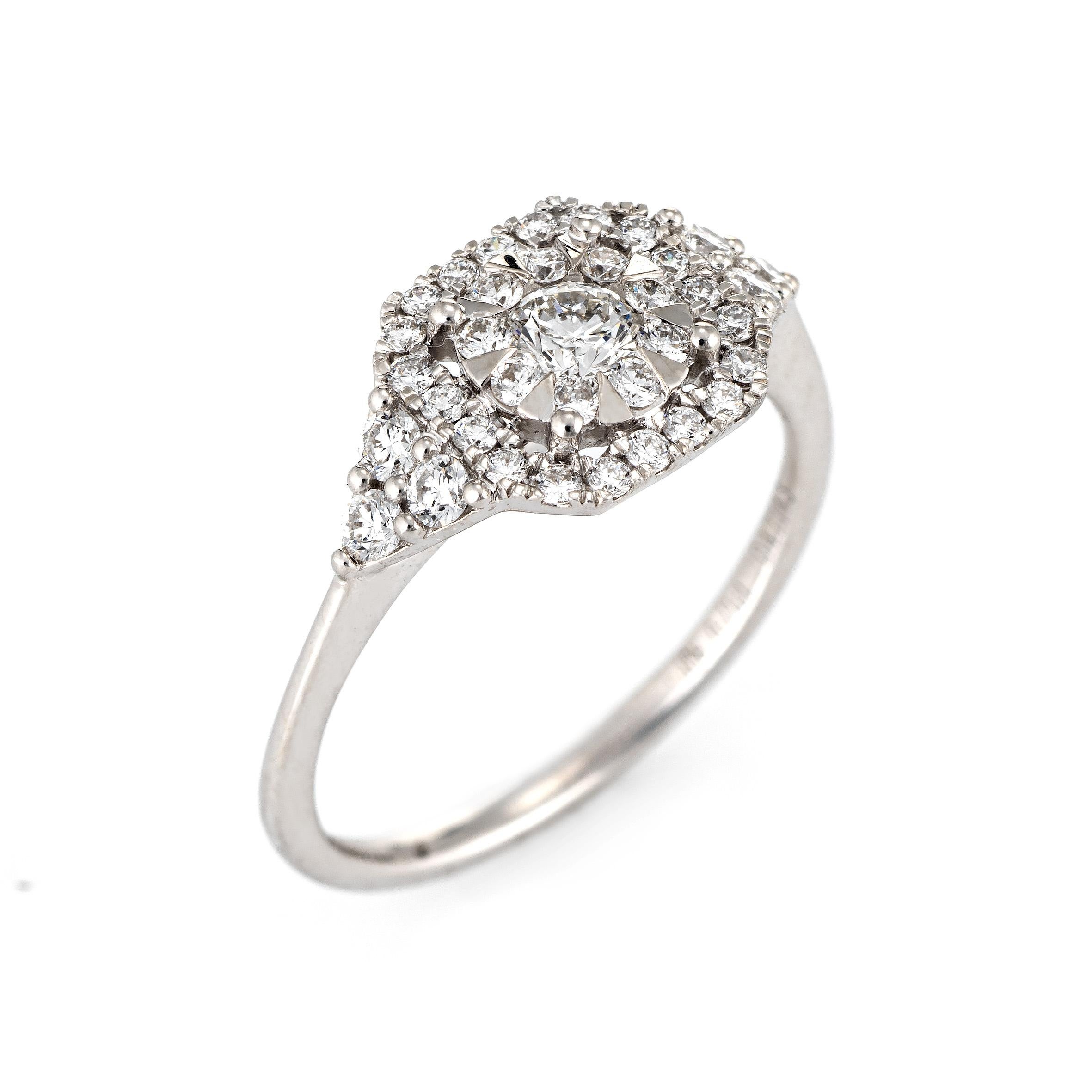 Stylish estate Memoire diamond cluster ring crafted in 18 karat white gold. 

Diamonds total 0.71 carats (estimated at G-H color and VS2-SI1 clarity). 

The diamonds are set in a cluster design within a square shaped mount. The statement ring is