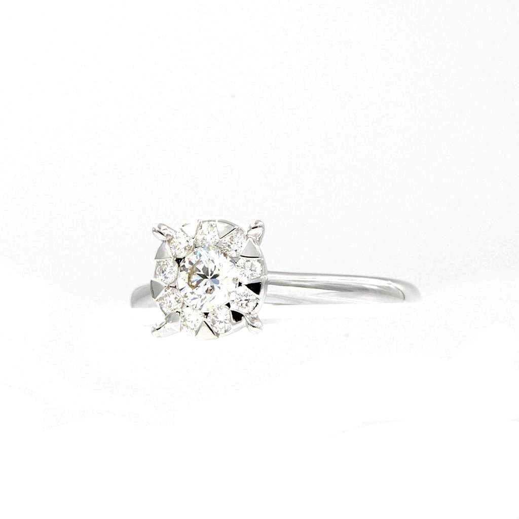 The Memoire Bouquets Collection Engagement Diamond Ring 0.65 ctw resembles a 2 carat diamond. The center diamond is 0.50 ct while the side diamonds are 0.14 ct in size, with a G color and SI clarity. The ring is made of 18K white gold and is