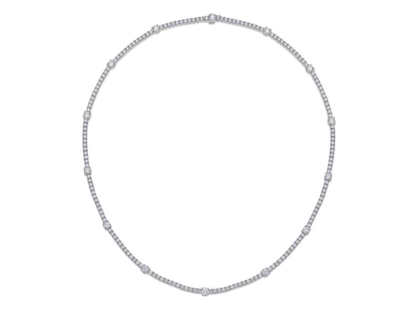 This 18 karat white gold diamond station tennis necklace by Memoire is composed of 184 round brilliant cut diamonds with a total weight of 6.42 carats. The stones boast F color and VS1 – VS2 Clarity with ideal cut and polish by Hearts on Fire. The