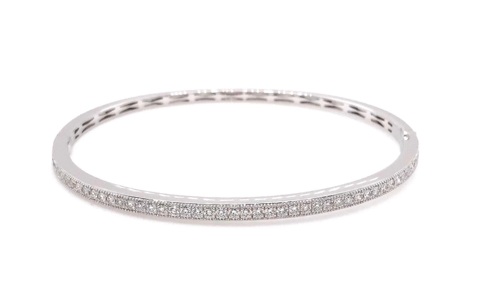 This Memoire Milgrain Hinge Bangle is crafted from 18K White Gold and is adorned with 46 Round Brilliant Cut Diamonds totaling 0.76 carats. With a width of 3 millimeters and a wrist diameter of 2.5 inches, this bangle weighs 10.6 grams, adding an