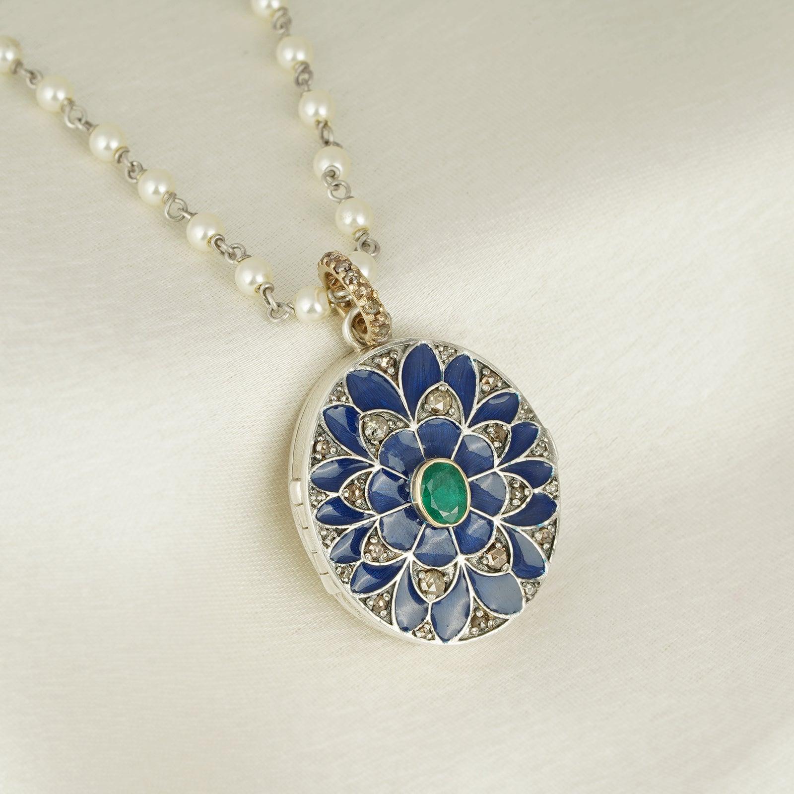Gold(14K) : 1.92g
Rose-cut Diamonds : 0.67ct
Gemstone : Emerald, Shell Pearl
Other : Blue Enamel
925

A photo is the most prime source of memories. As a pendant, it stays close to your heart, has an aesthetic appeal but it also holds stories on the