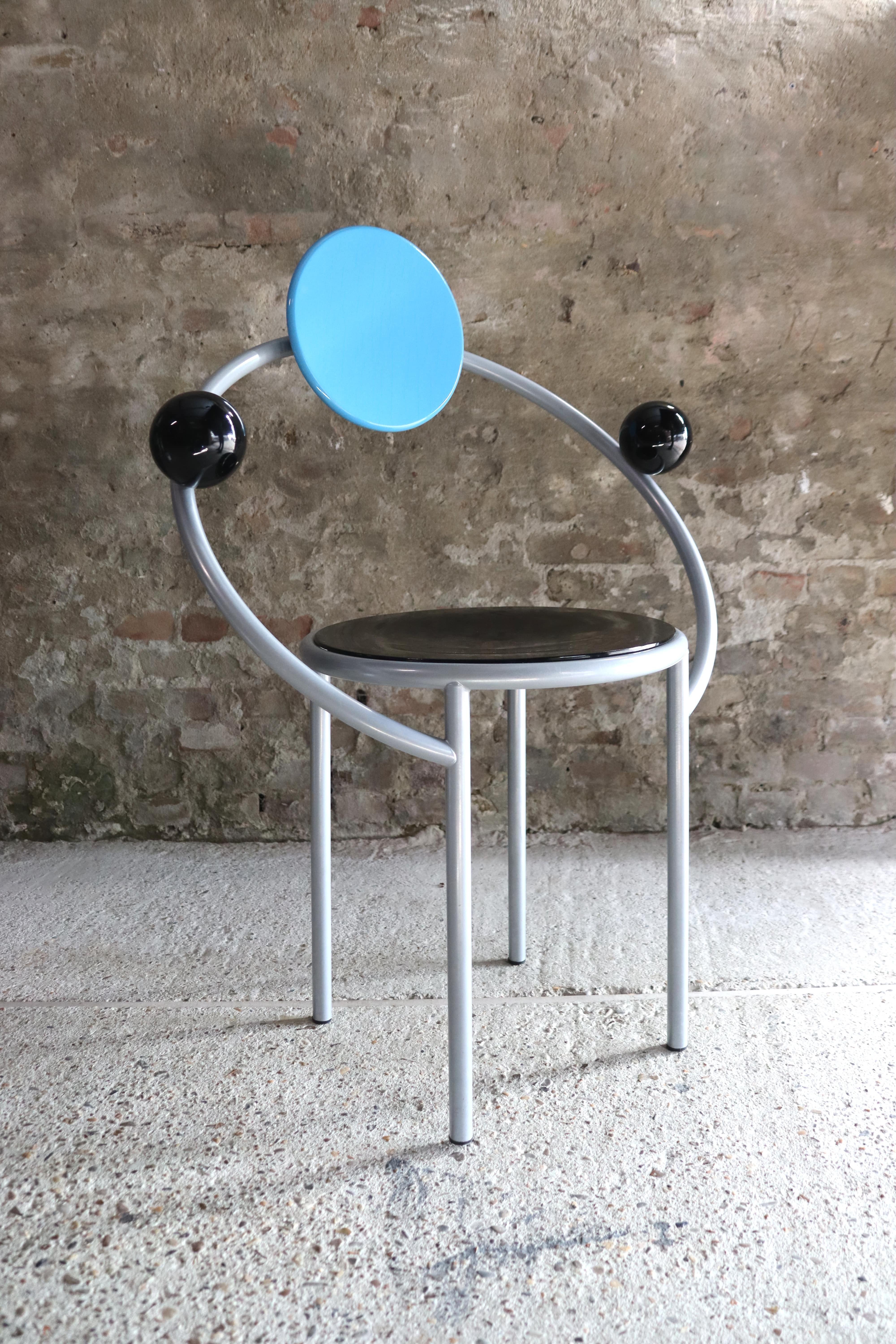 Striking and bold, this chair designed by Michele De Lucchi in 1983 for Memphis will be a superb addition to a contemporary dining room, study, or entryway when used as a unique accent piece. The sophisticated design evokes planetary orbits in a
