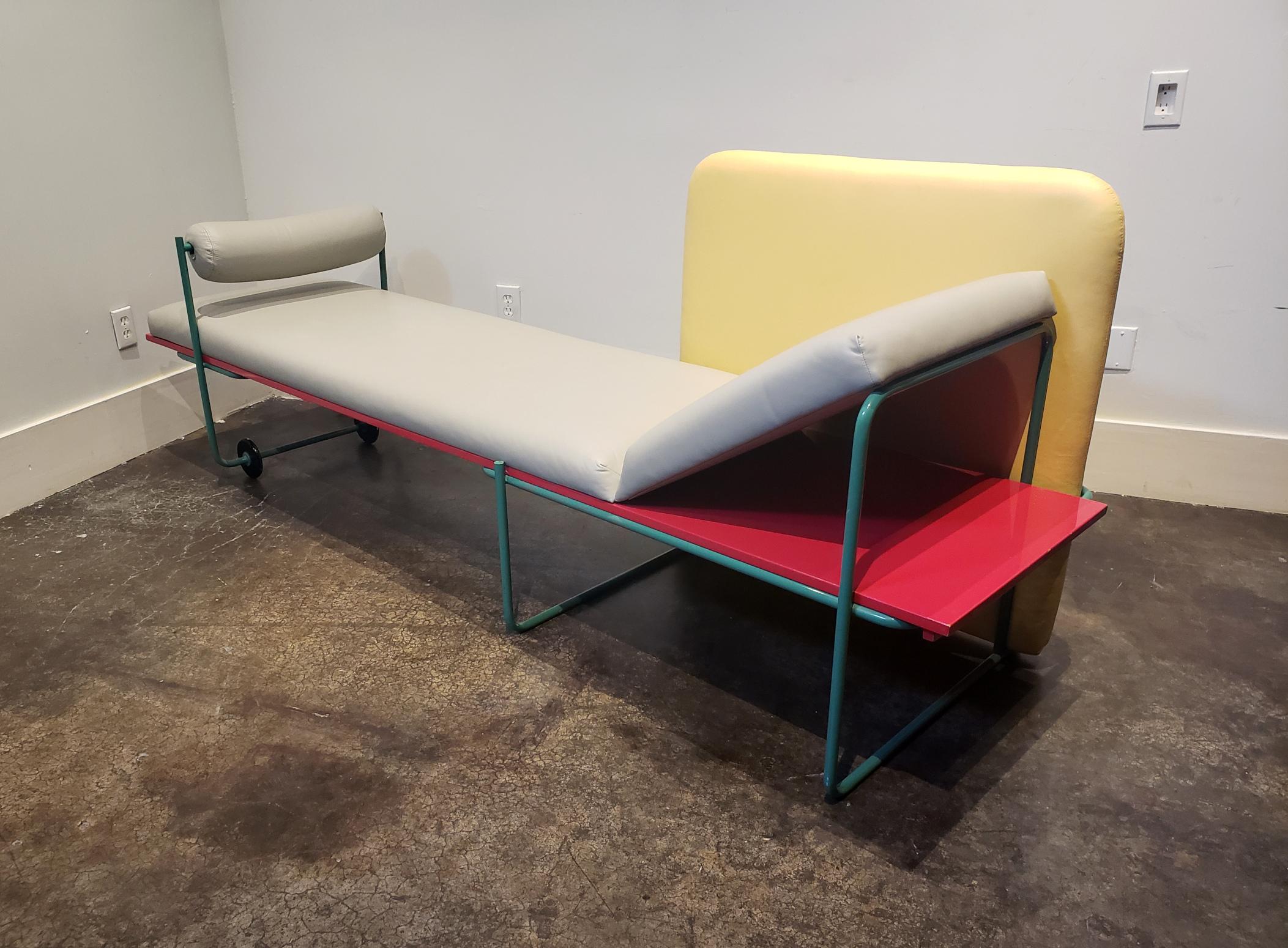 Very rare Memphis Milano sofa designed by Andea Branzi in 1982. Lacquered wood in red, lacquered metal in green, gray and yellow leather upholstery. Chaise can be rolled on wheels and the head rest on the right can be raised or laid