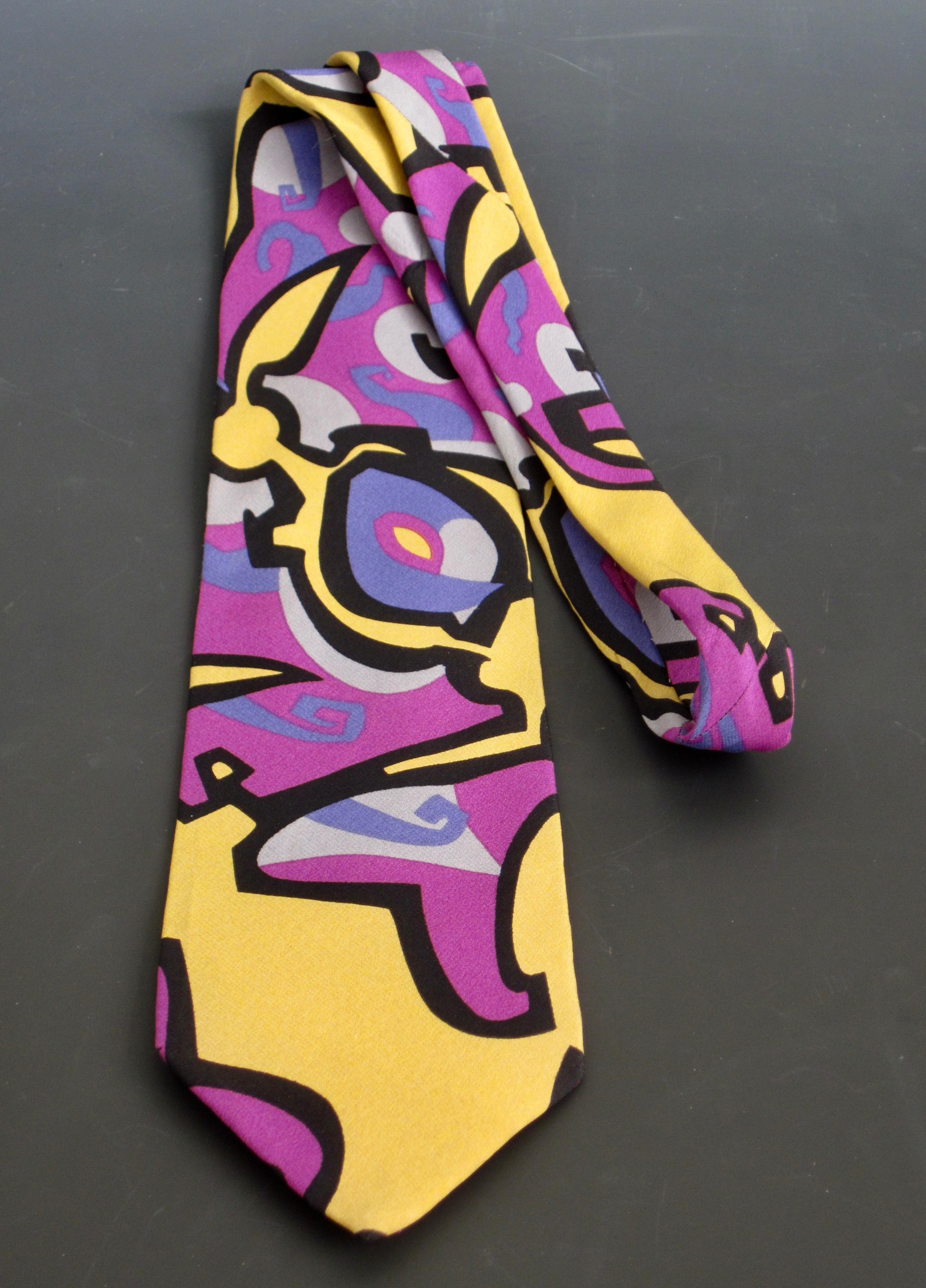 Stand out with this fabulous Memphis Milano tie! circa 1985, this 100% silk necktie features a brightly colored abstract design that was created by Memphis Milano guest designer, G. Della Vittoria. Comprised of black outlined magenta, periwinkle,