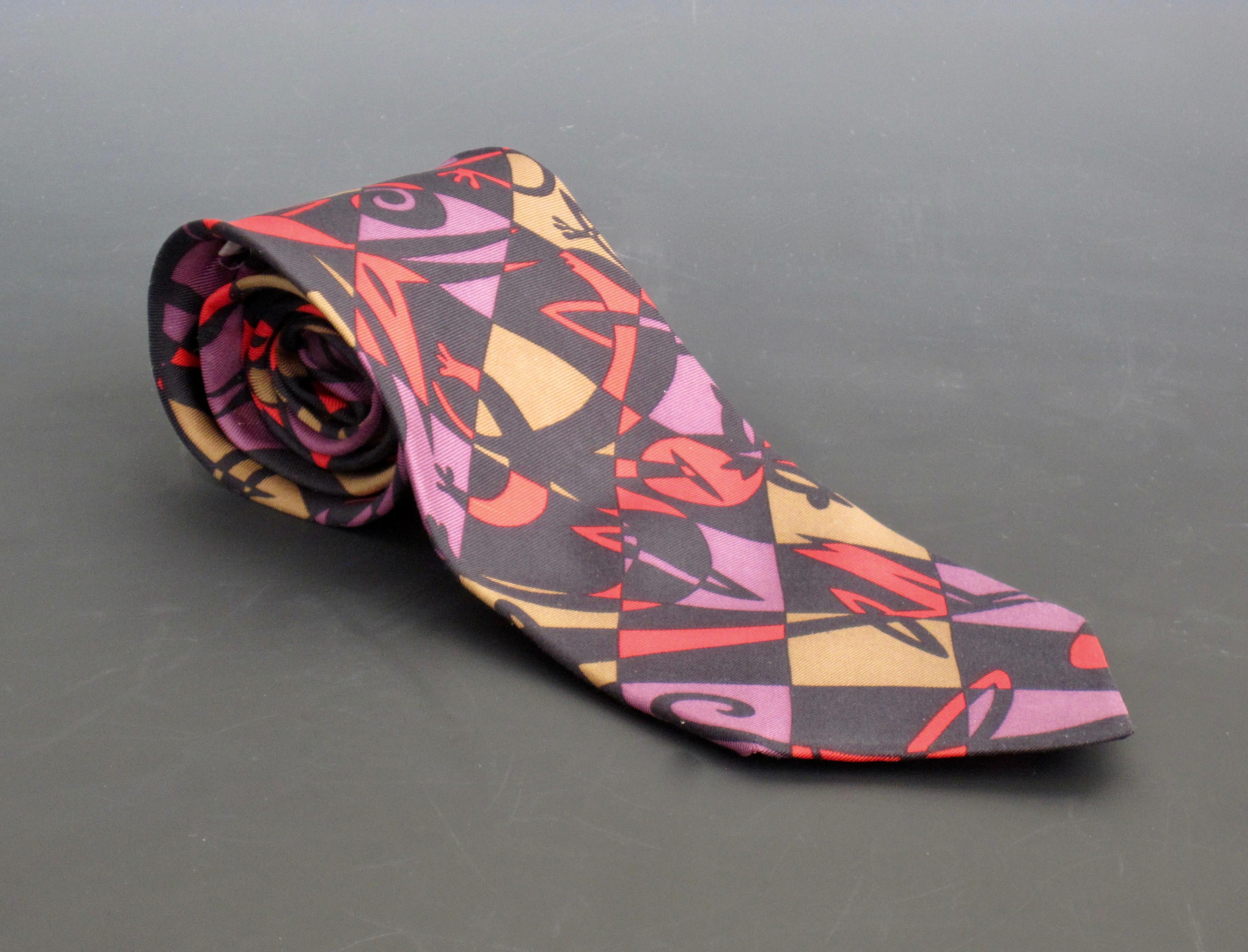 Abstract shapes on a harlequin background in red, purple, black and gold In a comic book like fashion, Massimo Giacon nails a sophisticated yet fun necktie design for the Memphis Milano Design Group. circa 1985. The Memphis Milano design movement