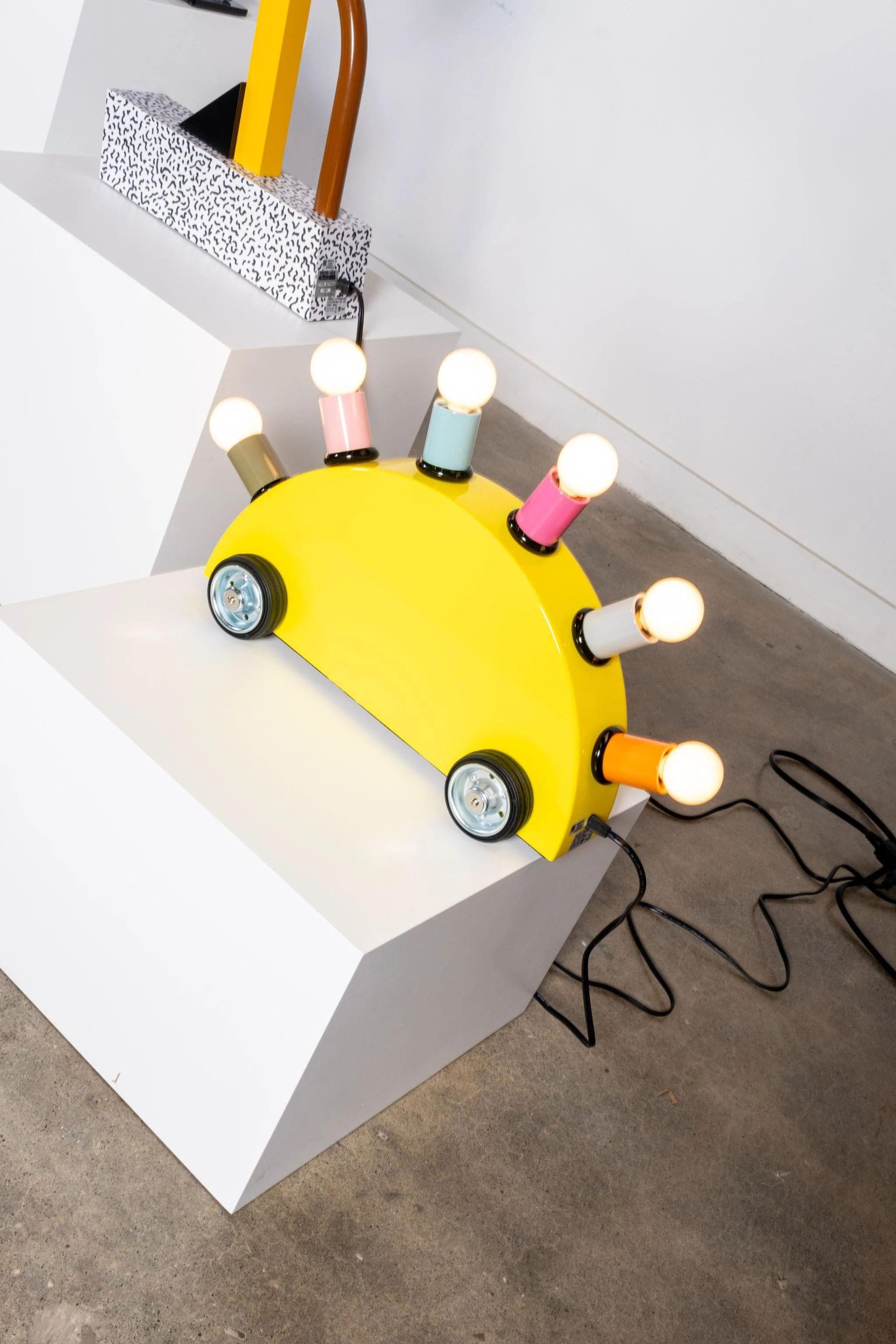 Lampadaire ou lampe de table en polyuréthane structurel et métal.

Démontrant l'esprit ludique de Memphis, le Can de Martine Bedin peut être traîné comme un chiot en laisse (avec un dos arqué comme l'armure d'un stégosaure). Up&Up se compose d'un