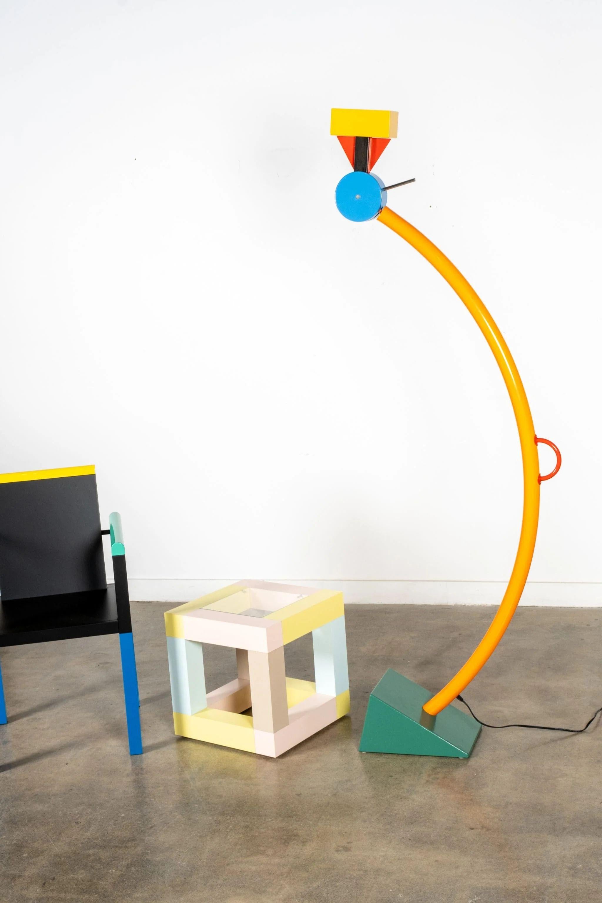 Treetops by Ettore Sottsass n'est pas une simple lampe, mais une véritable présence dynamique, élancée et colorée, capable d'insuffler, par son allure vivante, joie et légèreté à n'importe quel environnement. Le nom Treetops fait ironiquement