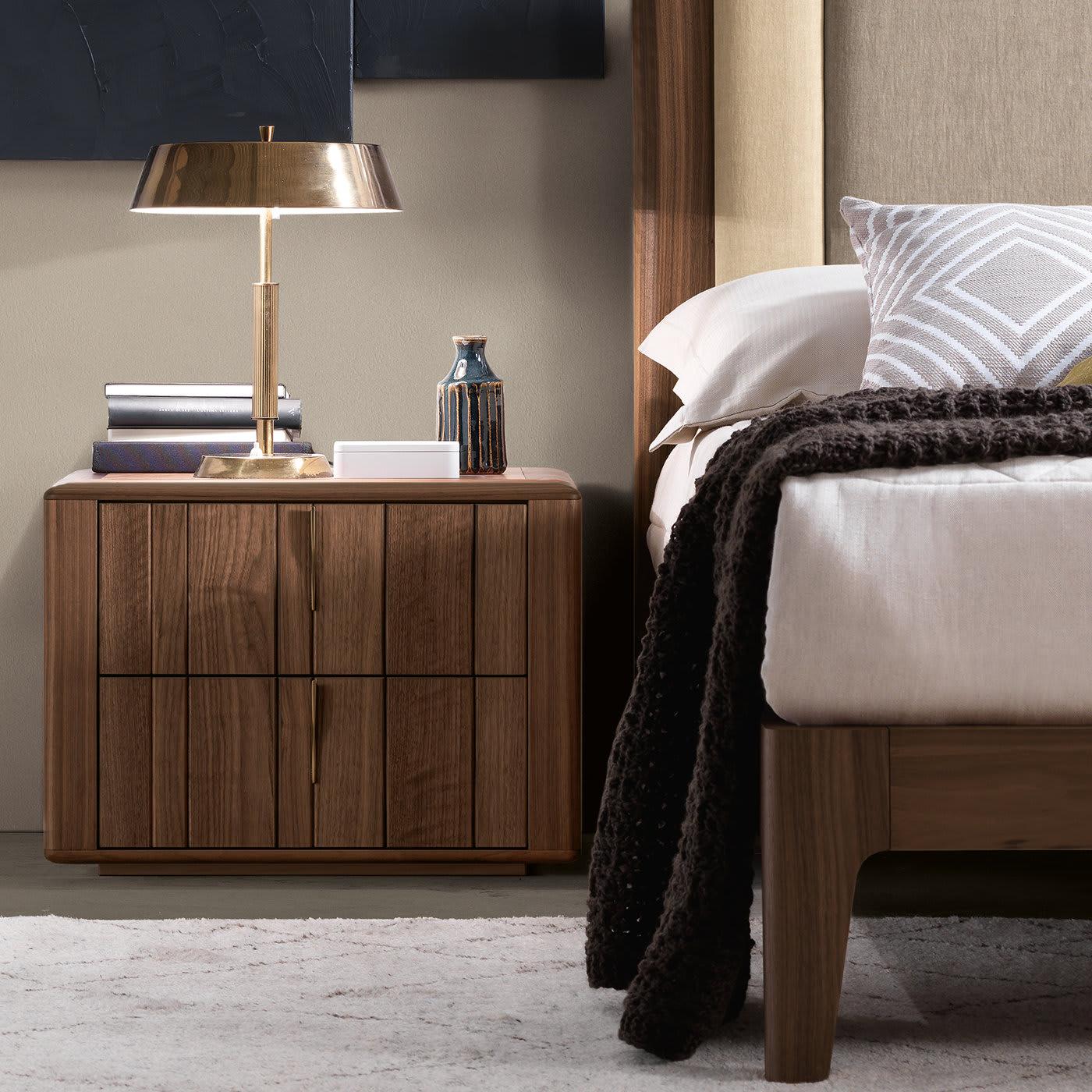 Créez une atmosphère chaleureuse dans une chambre à coucher contemporaine avec la table de nuit Memphis. En bois de noyer, la pièce peut être personnalisée avec diverses options, notamment des lattes de bois rayées ou quadrillées. Les deux tiroirs
