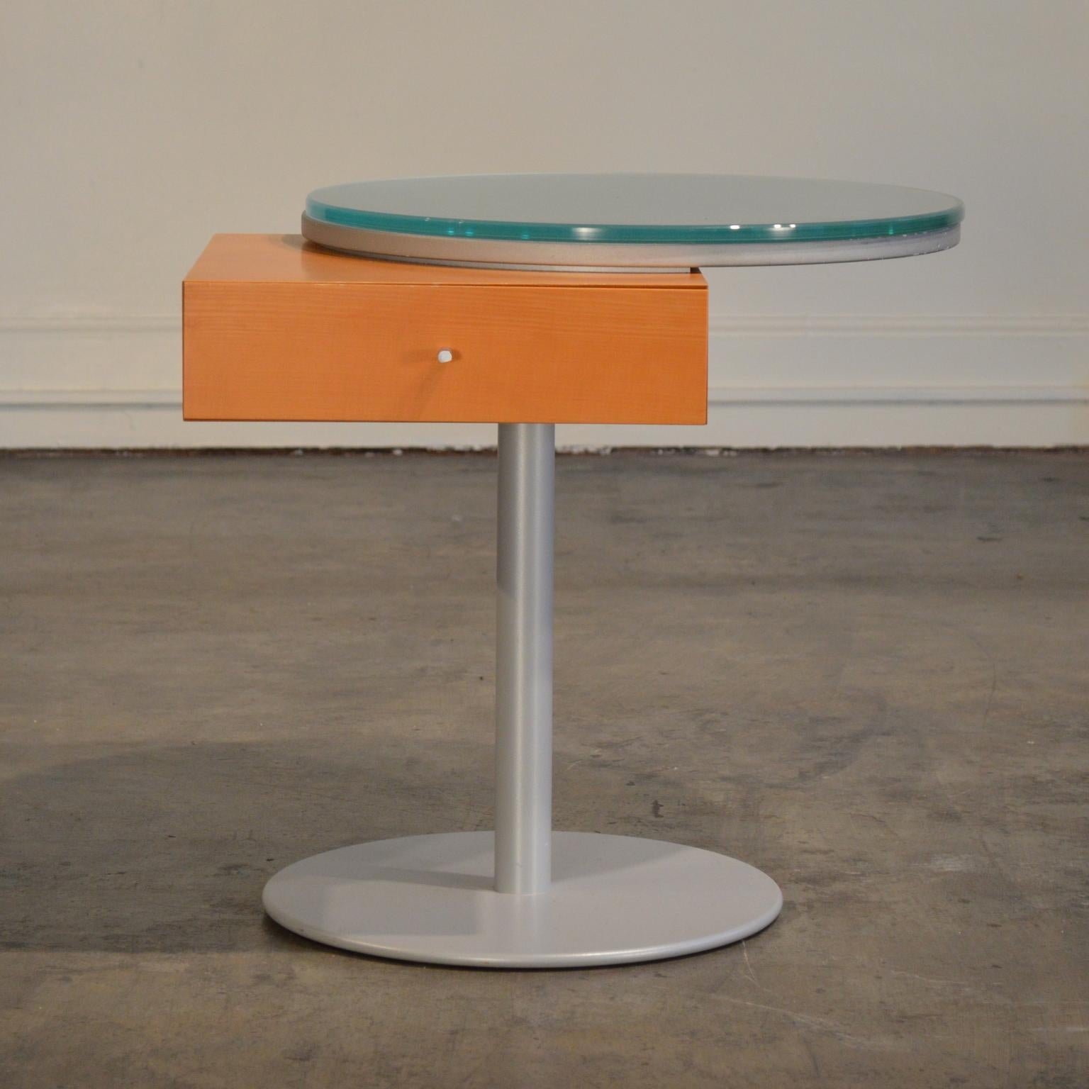 Side table with clear Memphis style - geometric shapes with a playfulness that extends Bauhaus forms with joyful humanism. A seamless box atop enameled steel base with asymmetrically mounted round tabletop with thick cast glass surface.

Heavy and