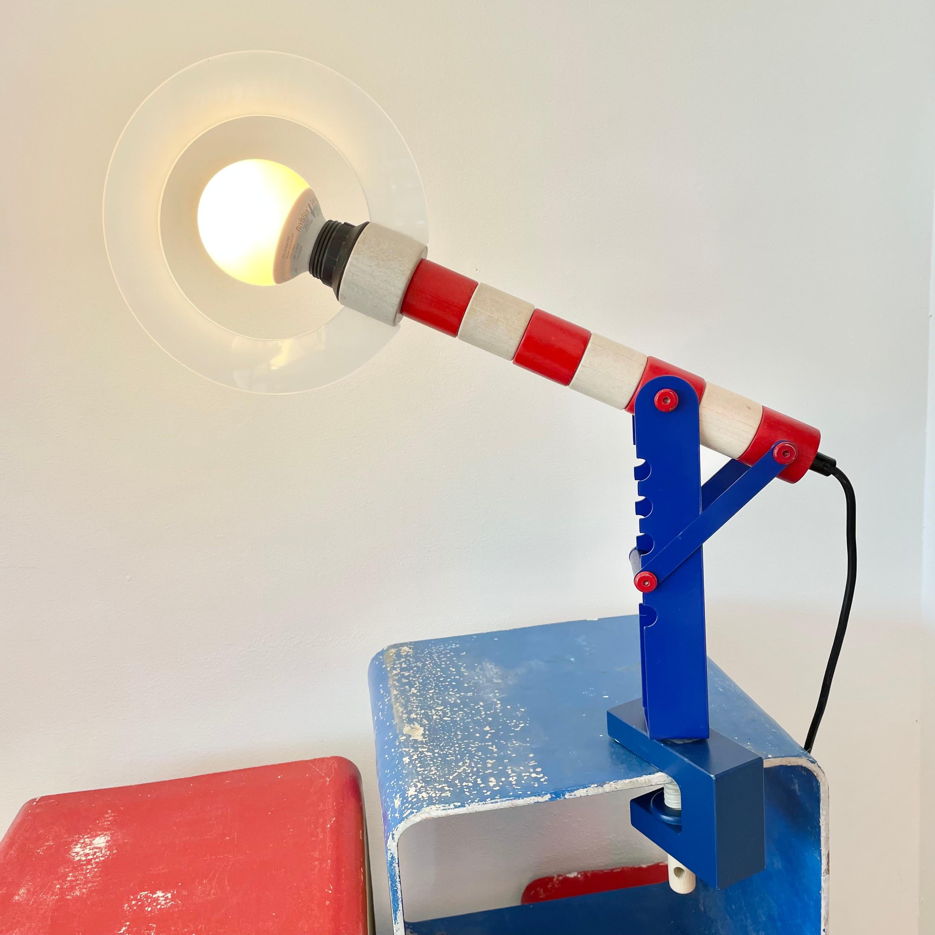 Great Postmodern wood lamp by Haba, Germany. Made in the 1980s. Wood dowel tightens the base so that it can clamp on to a desktop/tabletop/shelf. Height is adjustable. Painted wood and metal. Rotates 360 degrees. Great colors. Fantastic piece of
