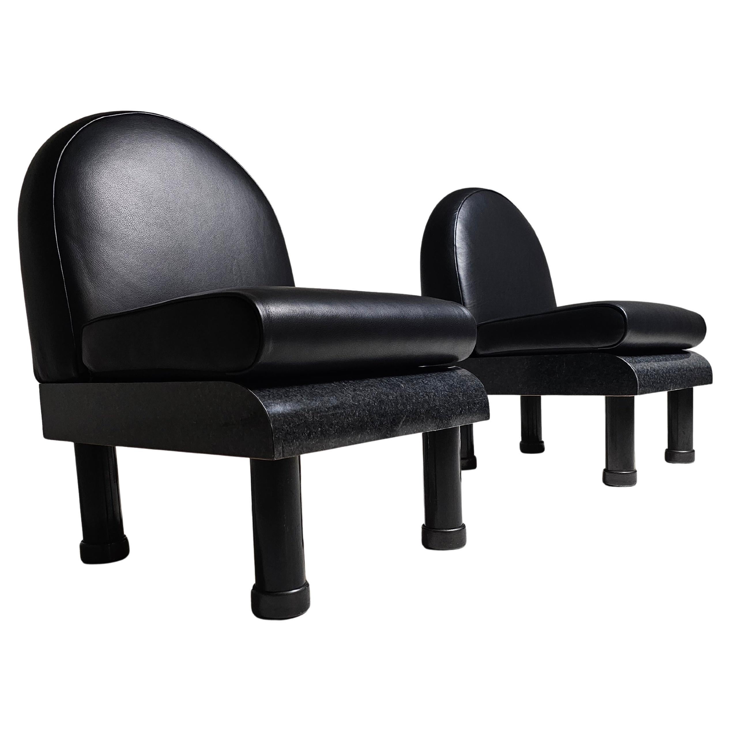 These on of a kind Memphis-style chairs capture the essence of postmodern design with their bold shapes. The backrests feature a curved silhouette reupholstered in a stunning black leather. The seats, finished in a glossy dark grey laminate, offers
