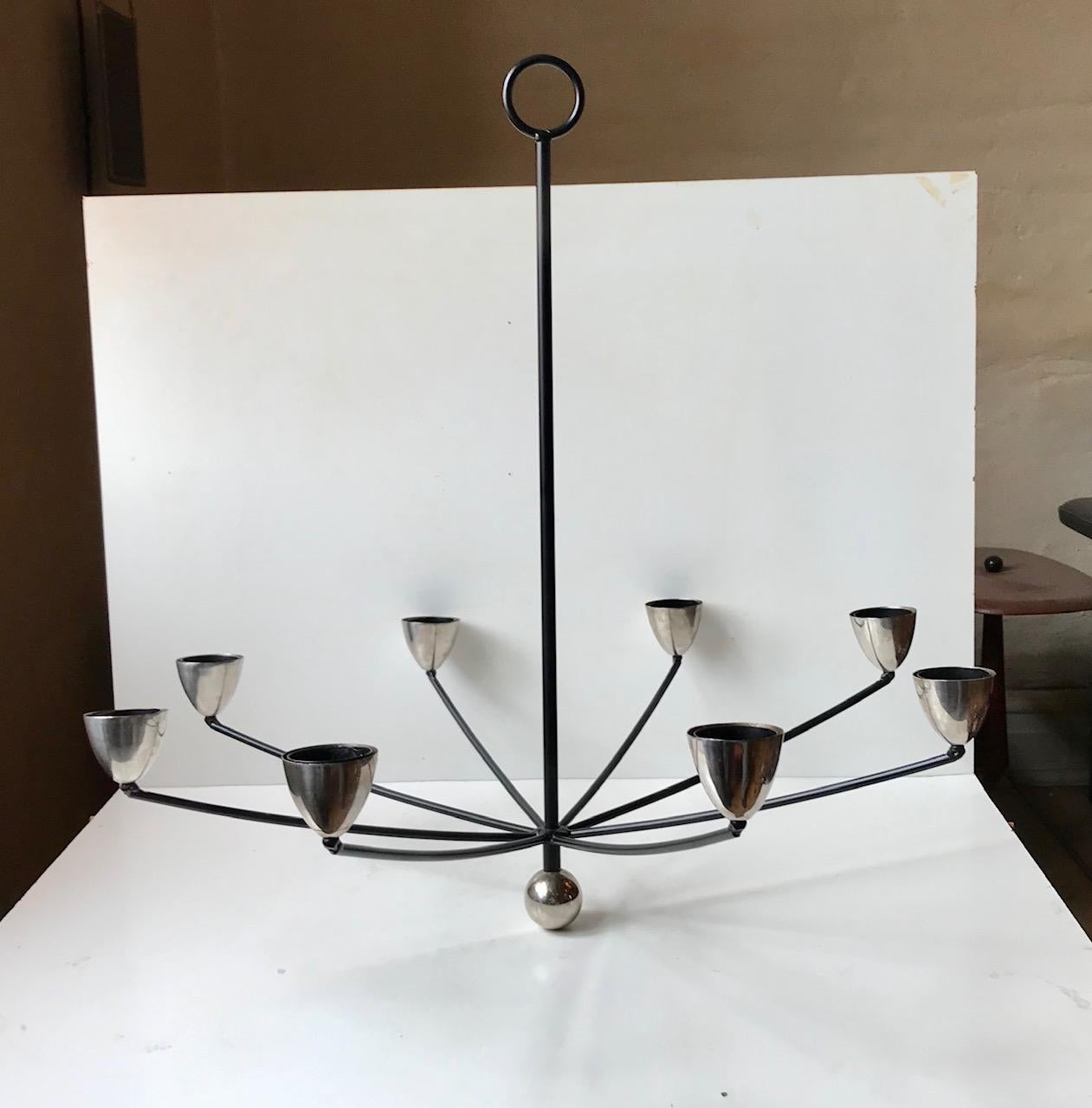 Stylized chandelier in chromed plated and black iron. It is to be installed with up to 8 tea lights or suitable bloc candlelight. Anonymous Scandinavian maker circa 1980-90.