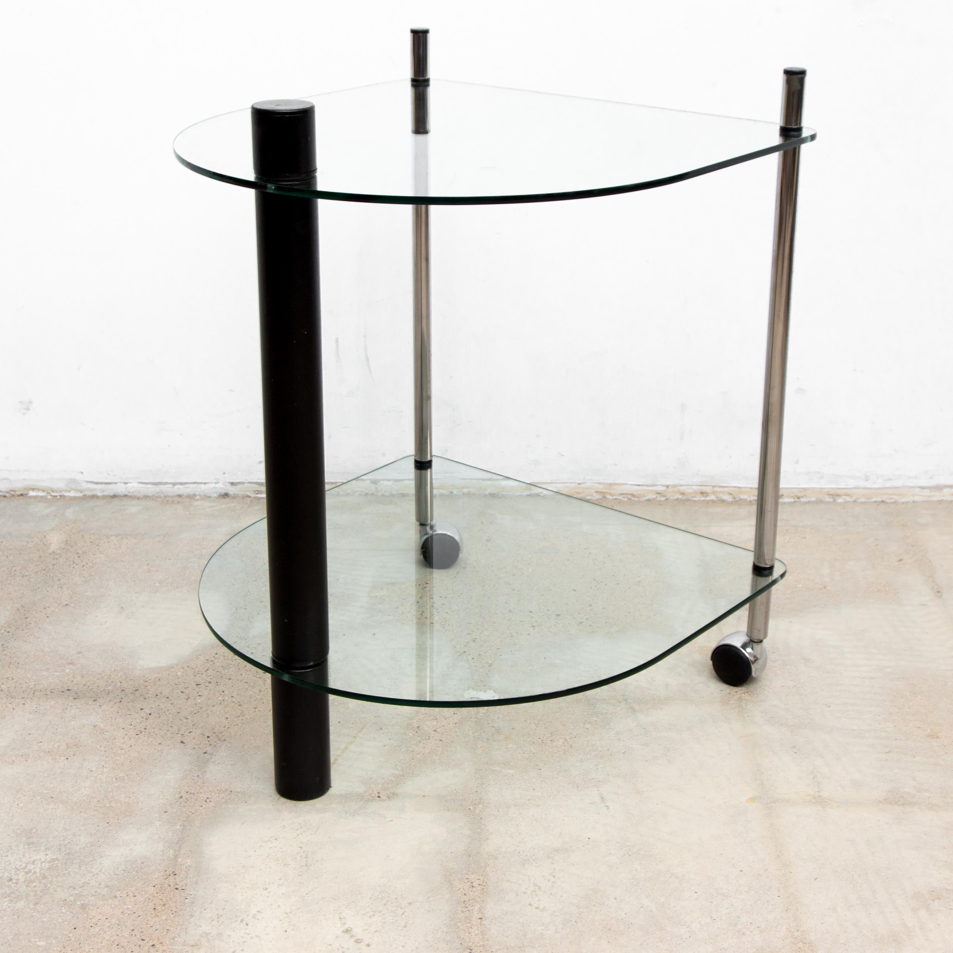 This 1980’s styled cocktail cart , is designed in the archetype materials and geometric shapes of the 1980’s Memphis style. Hardened glass tops a black lacquered metal stand and chrome plated legs on wheels. Perfect simplicity.

Serve your dirty