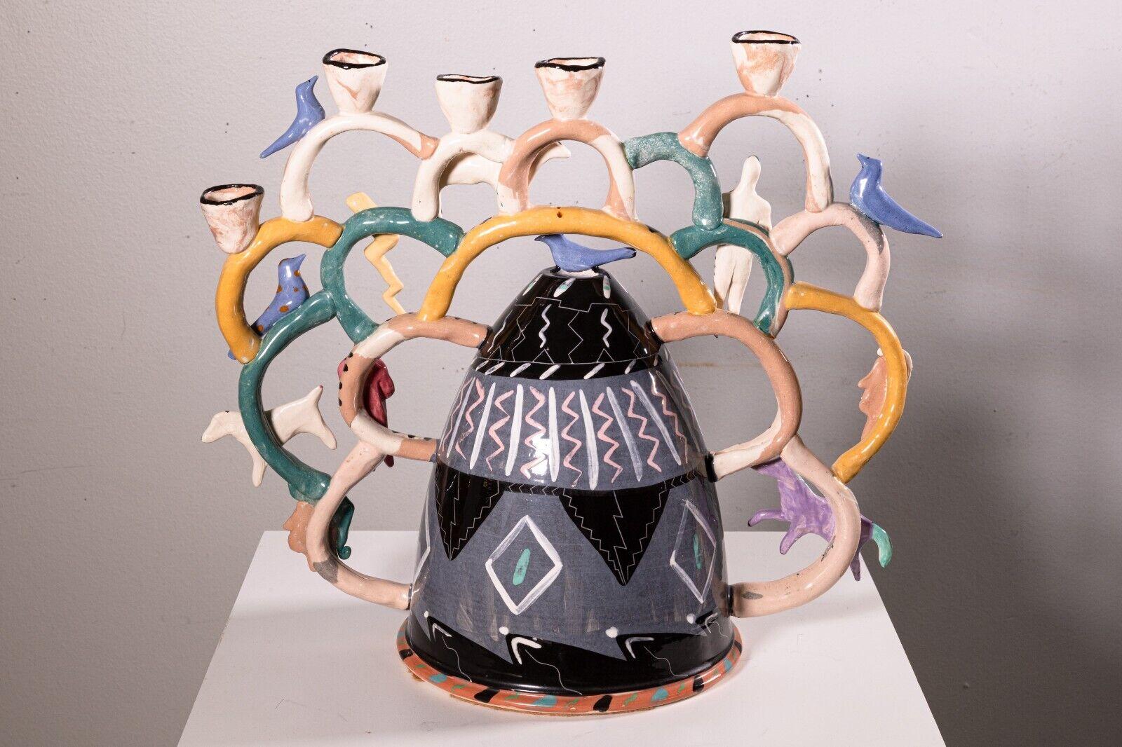 A Garson Pakele candle holder. A very unique, eclectic candle holder, from Garson Pakele. This super fun, hand made candle holder can support five candles on top, and a candle within the inside of the center housing as well. This piece features a