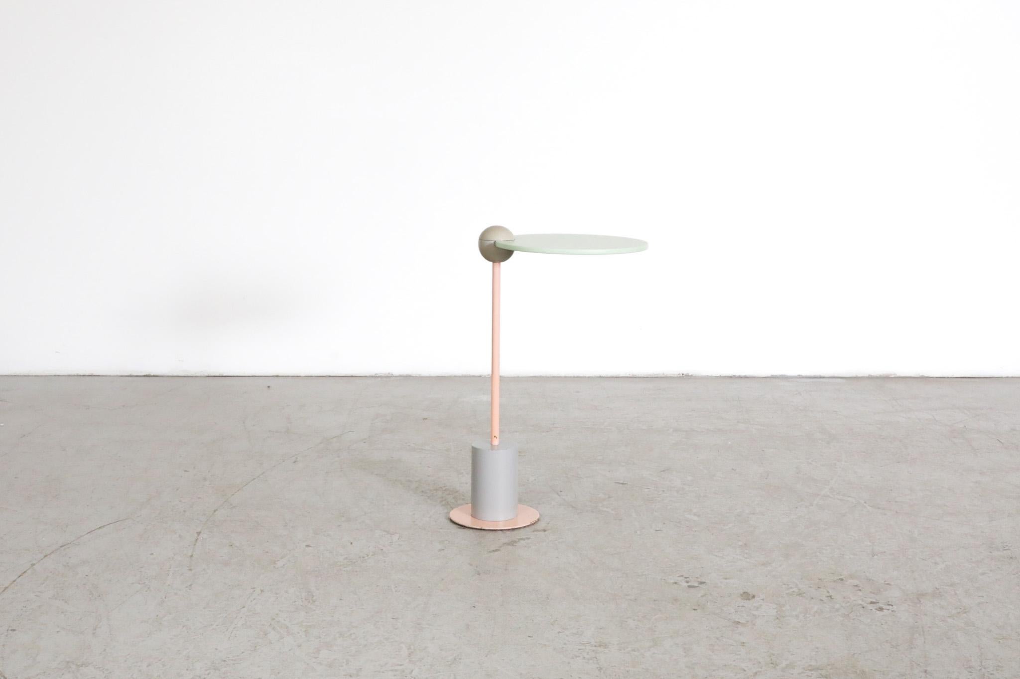 Sweet little Memphis style pink, grey and mint green lacquered 'Piccolo' side table with a heavy weighted steel base, designed by Edward Geluk for Arco in the early eighties. In original condition with visible wear, including some paint loss and