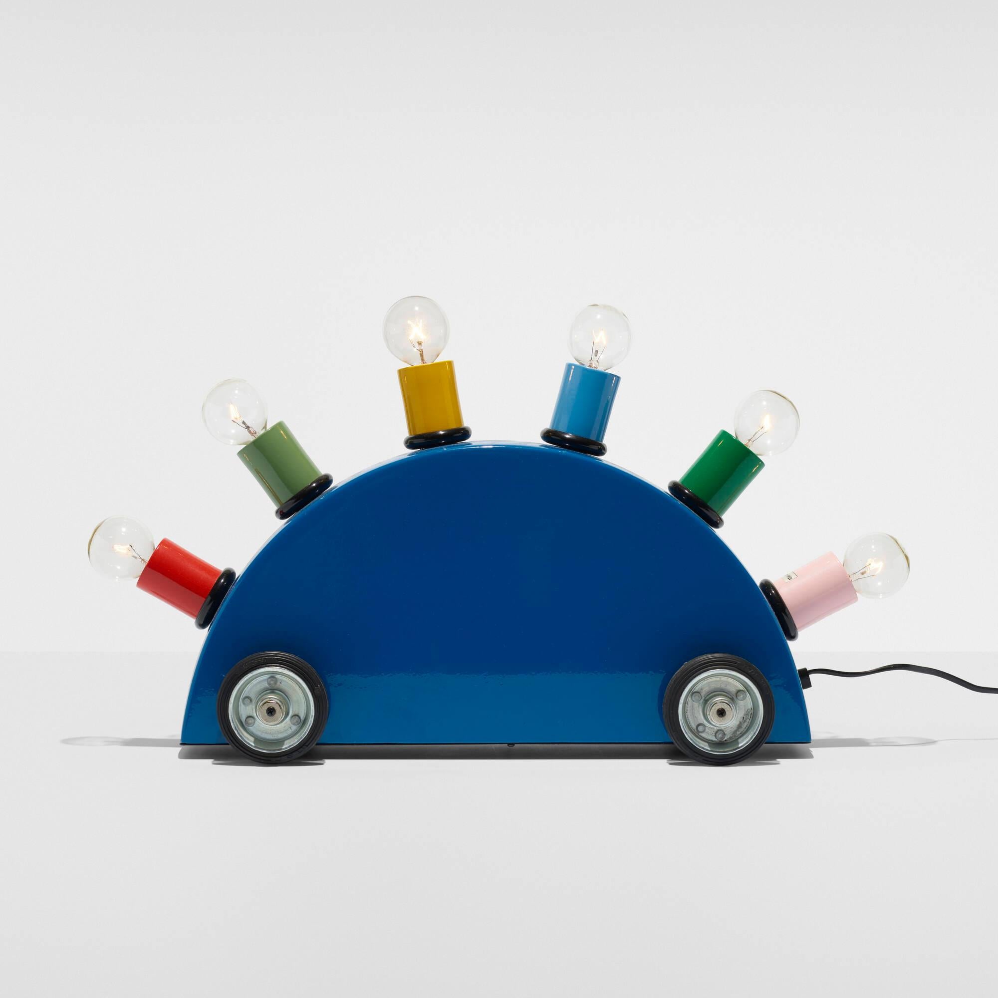 La superlámpara Clásica con ruedas de goma de la primera inceptora de Memphis, Martine Bedin (Francia).
La elegancia discreta se une al color llamativo de Memphis ¡todo en uno! 

Las lámparas son obra de Martine Bedin, uno de los miembros más