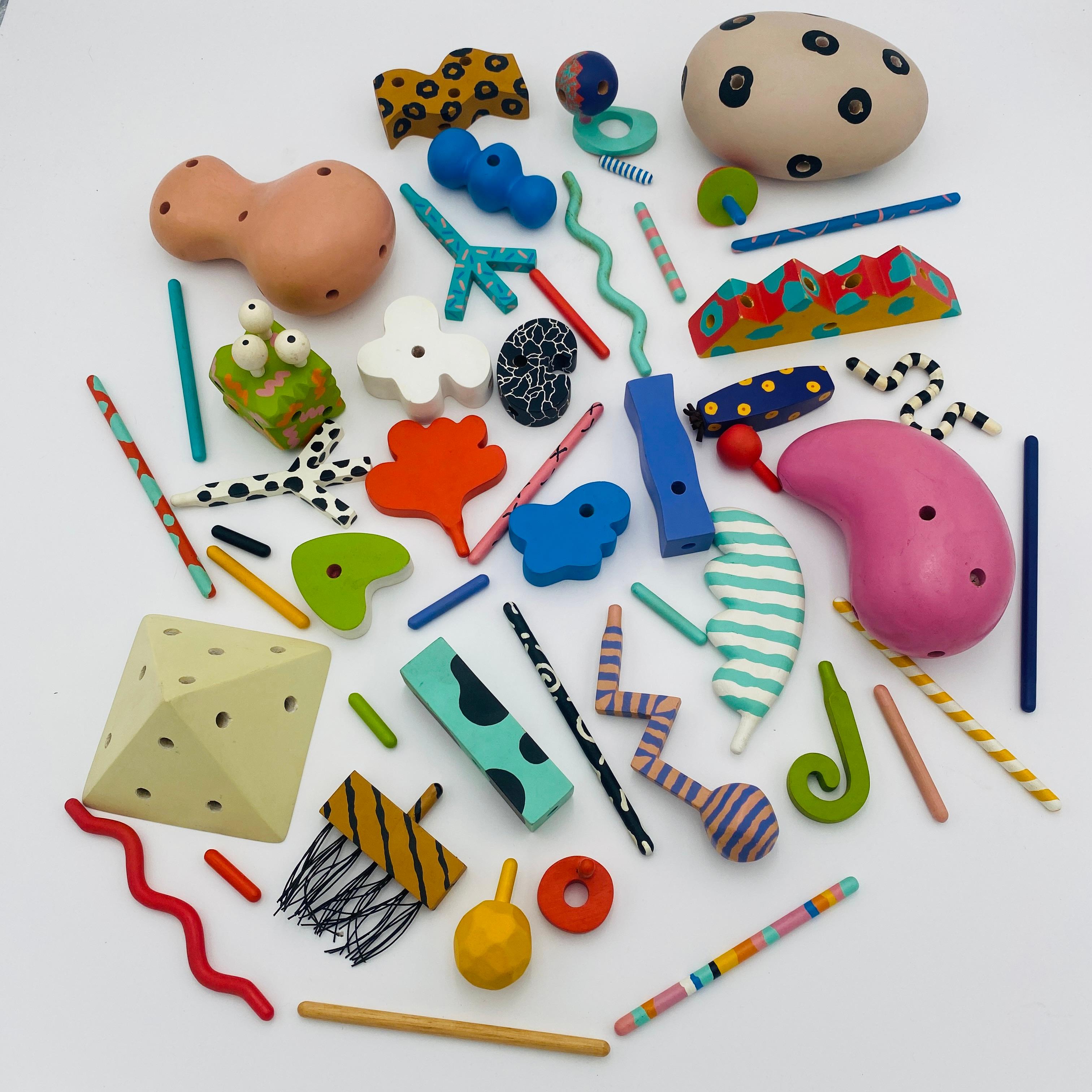 Ein Memphis Zolo Toys Set mit 54 Holzpuzzleteilen, entworfen von Byron Glaser und Sandra Higashi 1987 für das MOMA. Alle Teile bestehen aus Holz und sind handbemalt. Die seltenen Formen und farbenfrohen Gestalten regen deine Kreativität an, während