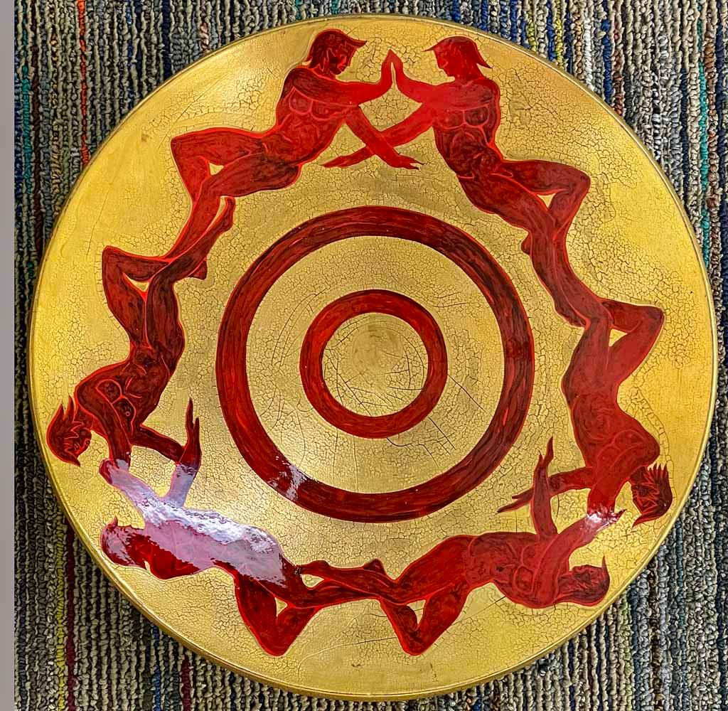 Très rare et extraordinaire par son sujet et sa palette, cette coupe basse à pied de style Art déco, réalisée par A. Mourier, représente six personnages masculins nus sur sa circonférence, bras dessus, bras dessous et main dans la main, tous peints
