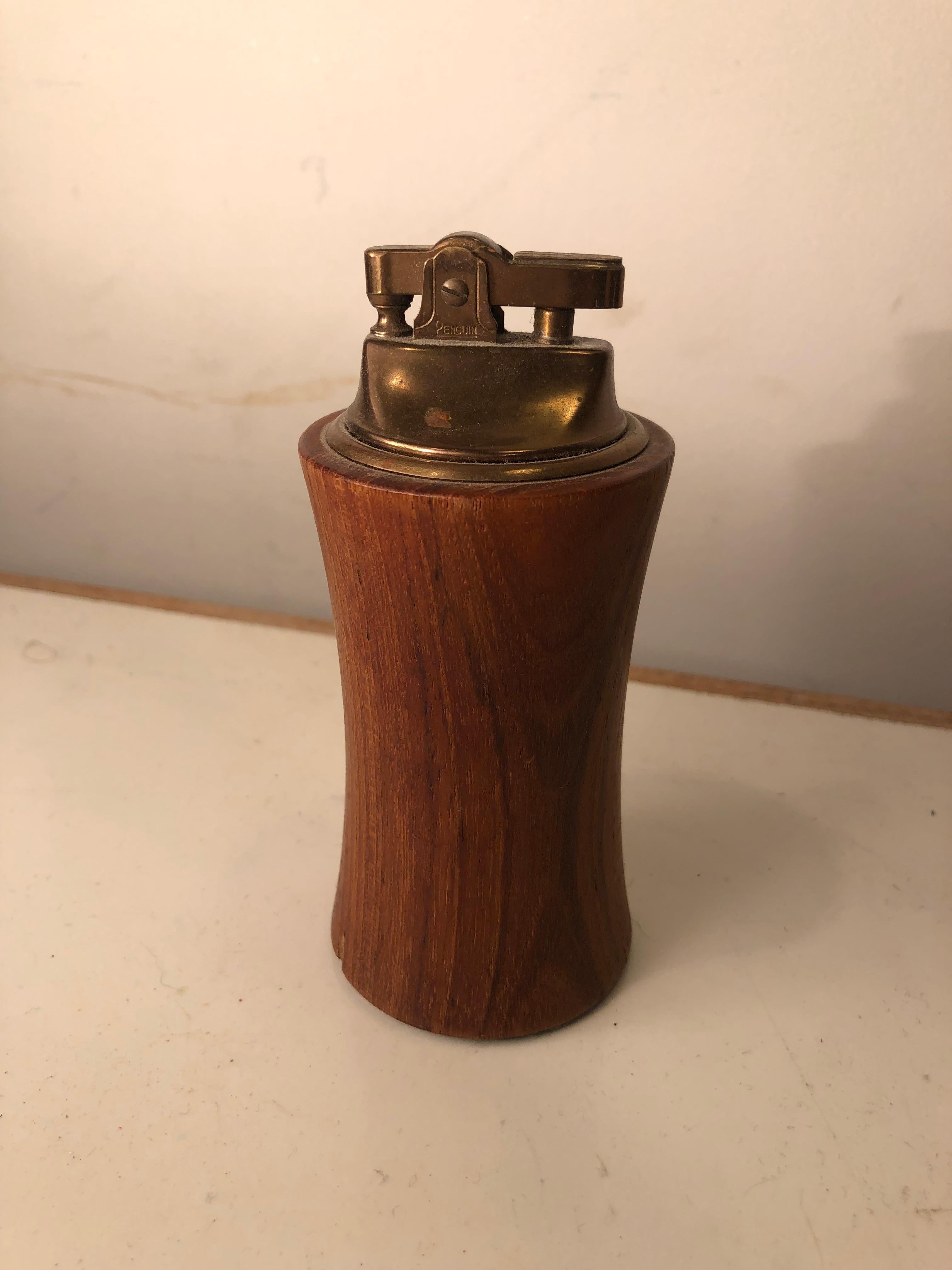 Can’t you picture Don Draper sparking this to light up and one of his lucky strike cigarettes? Hey handsome teak and brass midcentury table or desk lighter. Can be used as object d’art instead of for smoking. Untested.
