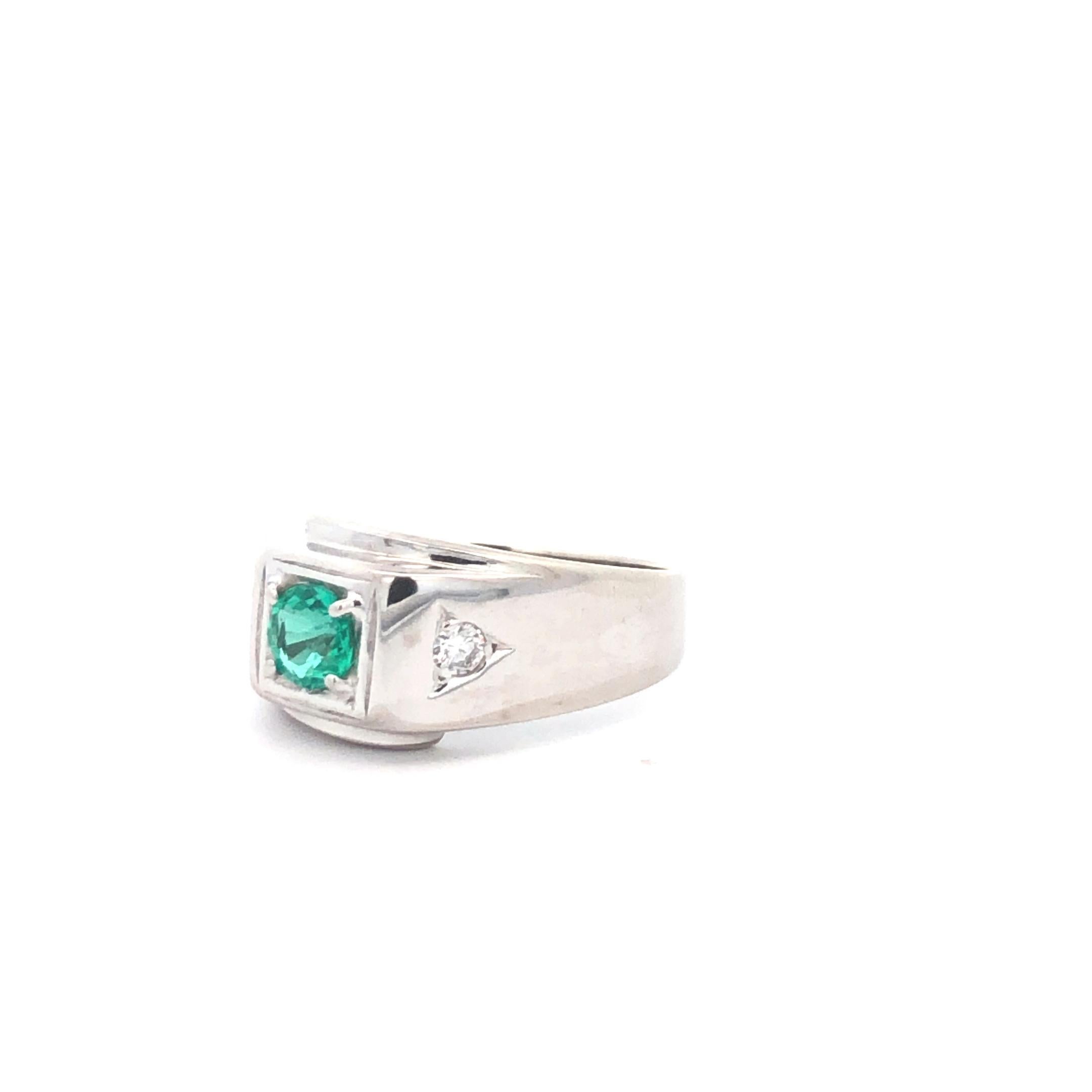 Dieser auffällige Ring für den kleinen Finger des Mannes aus 14 Karat Weißgold ist ein gewagtes Statement. Das Herzstück ist ein fesselnder Smaragd, der einen Hauch von lebendiger Farbe und Luxus verleiht. Der Ring ist außerdem mit ca. 0,10 Karat