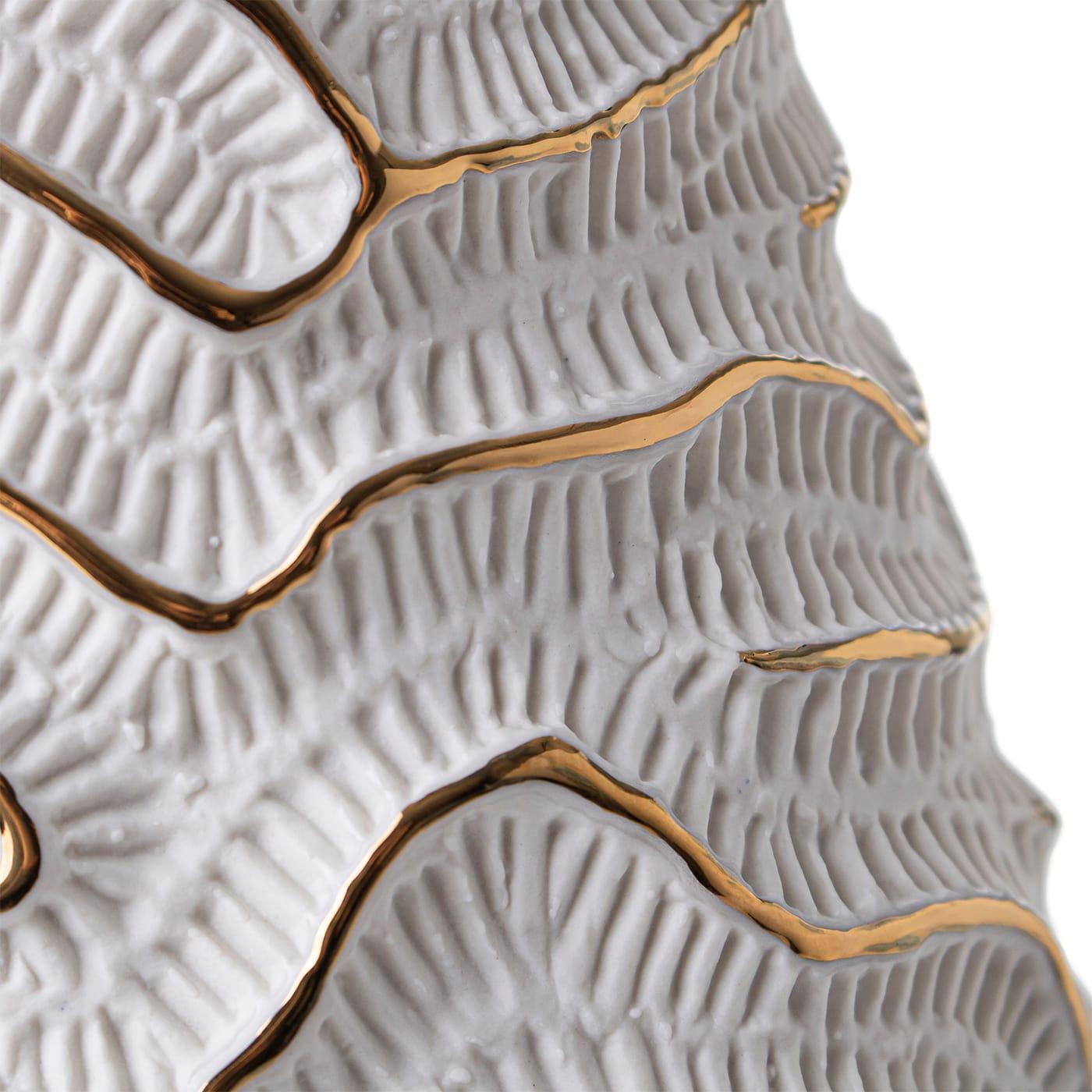 A mesmerizing texture, recalling fossils of madrepores, acts as a skeleton for this elegant vase of Fossilia collection. The original shape and the accuracy in the details of the unglazed porcelain make this piece an exquisite artwork. The vase is