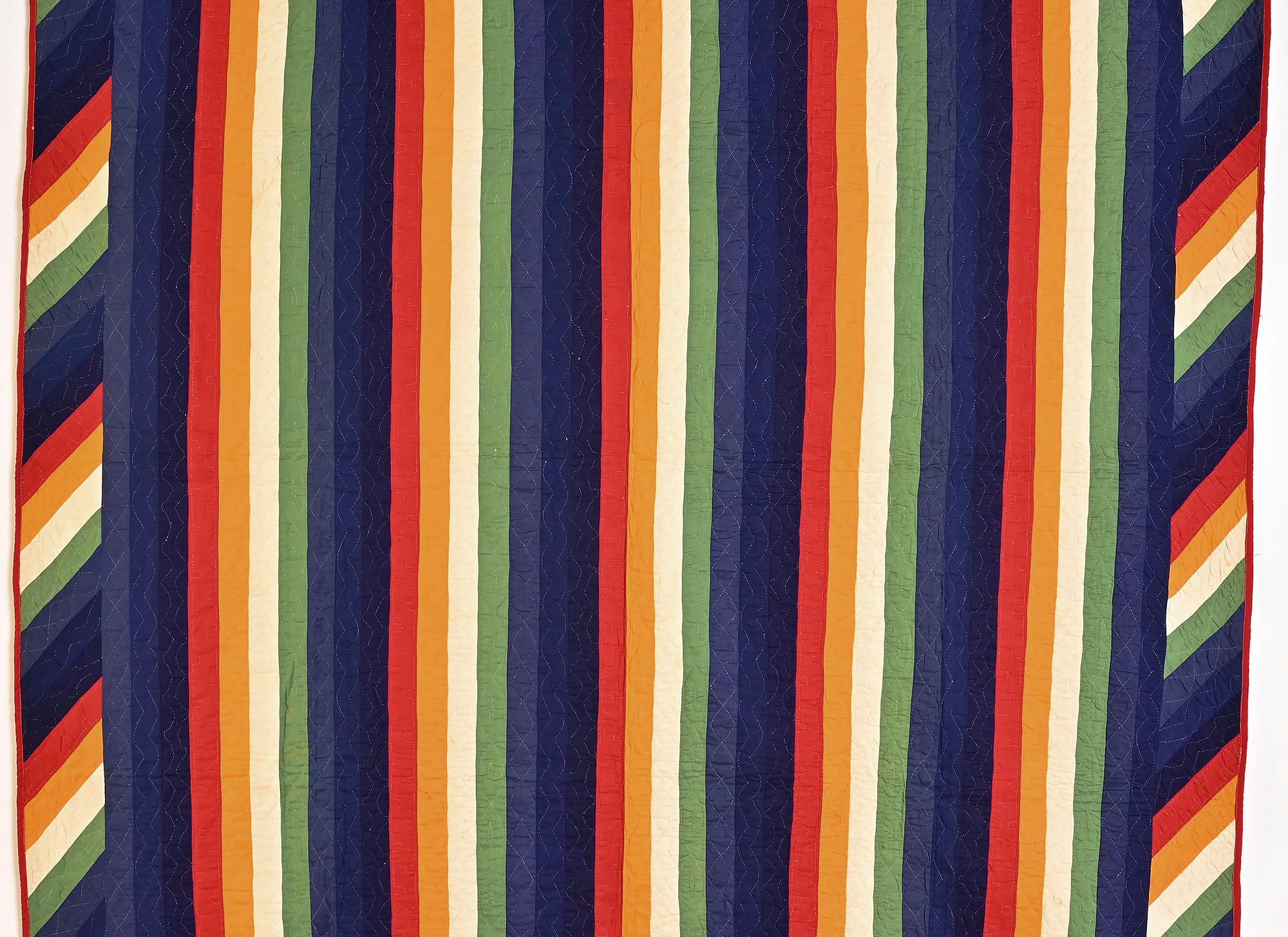 This striking Joseph's Coat quilt incorporates the features most desirable in this traditionally Mennonite pattern. Each color stripe has a different quilting pattern. The diagonal stripe border adds movement to the already bold design. What