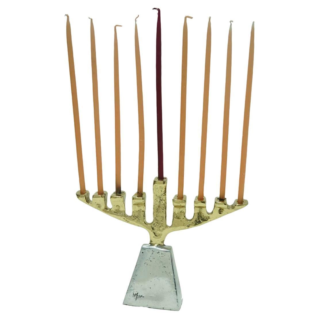 The decorative Menorah was created by David Marshall, it is made of sand cast aluminum and sand cast brass. 
We can engrave this piece with your Initials or Logo, makes a beautiful Wedding or Company Gift.
Handmade, mounted and finished in our