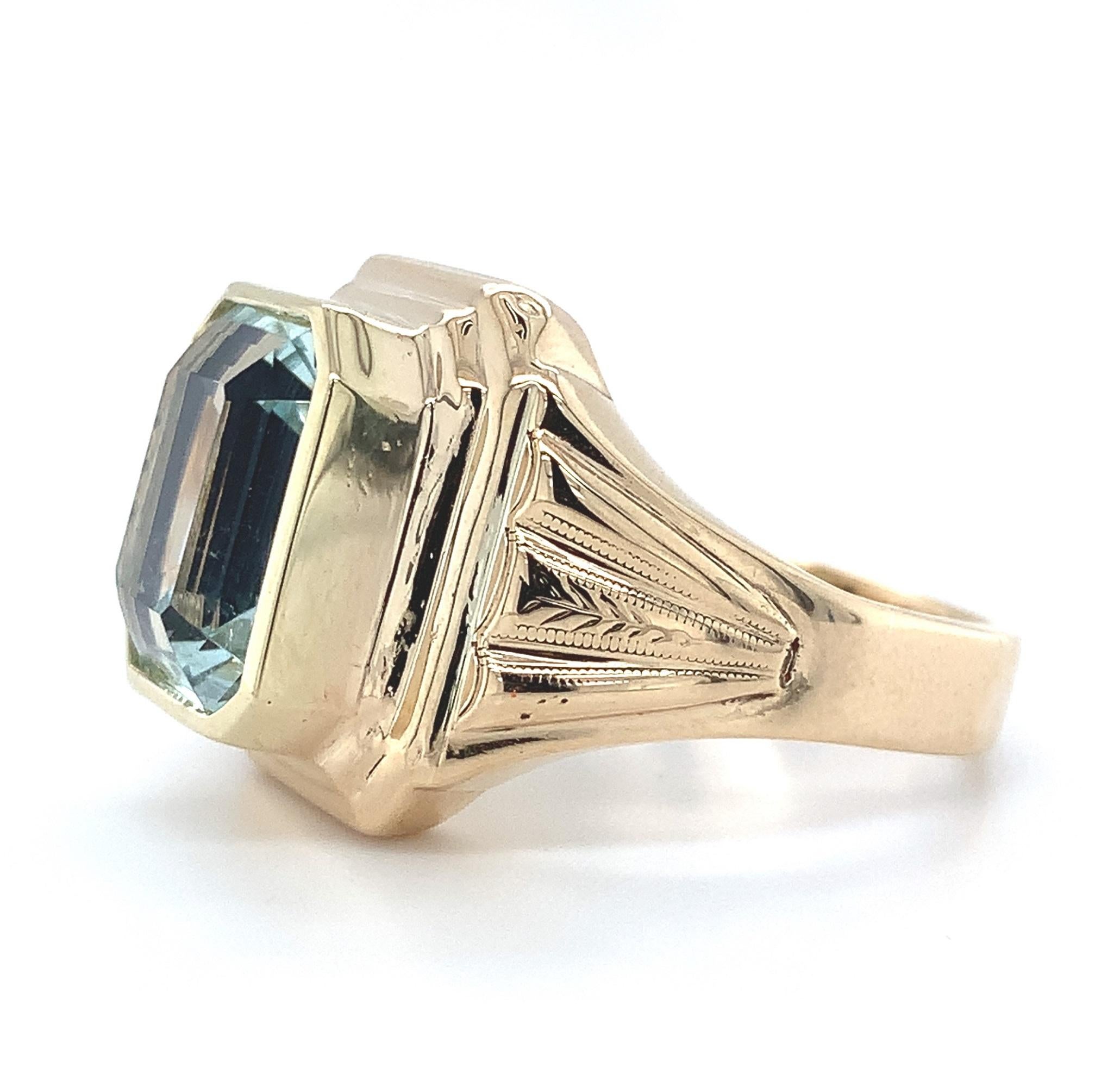 10K yellow gold men's ring featuring a large emerald cut aquamarine weighing 5.53 carats. The aquamarine measures about 11.5mm x 9.5mm and is set in a new bezel. The ring fits a size 9 finger and weighs 4.31dwt. It dates from the 1940's.