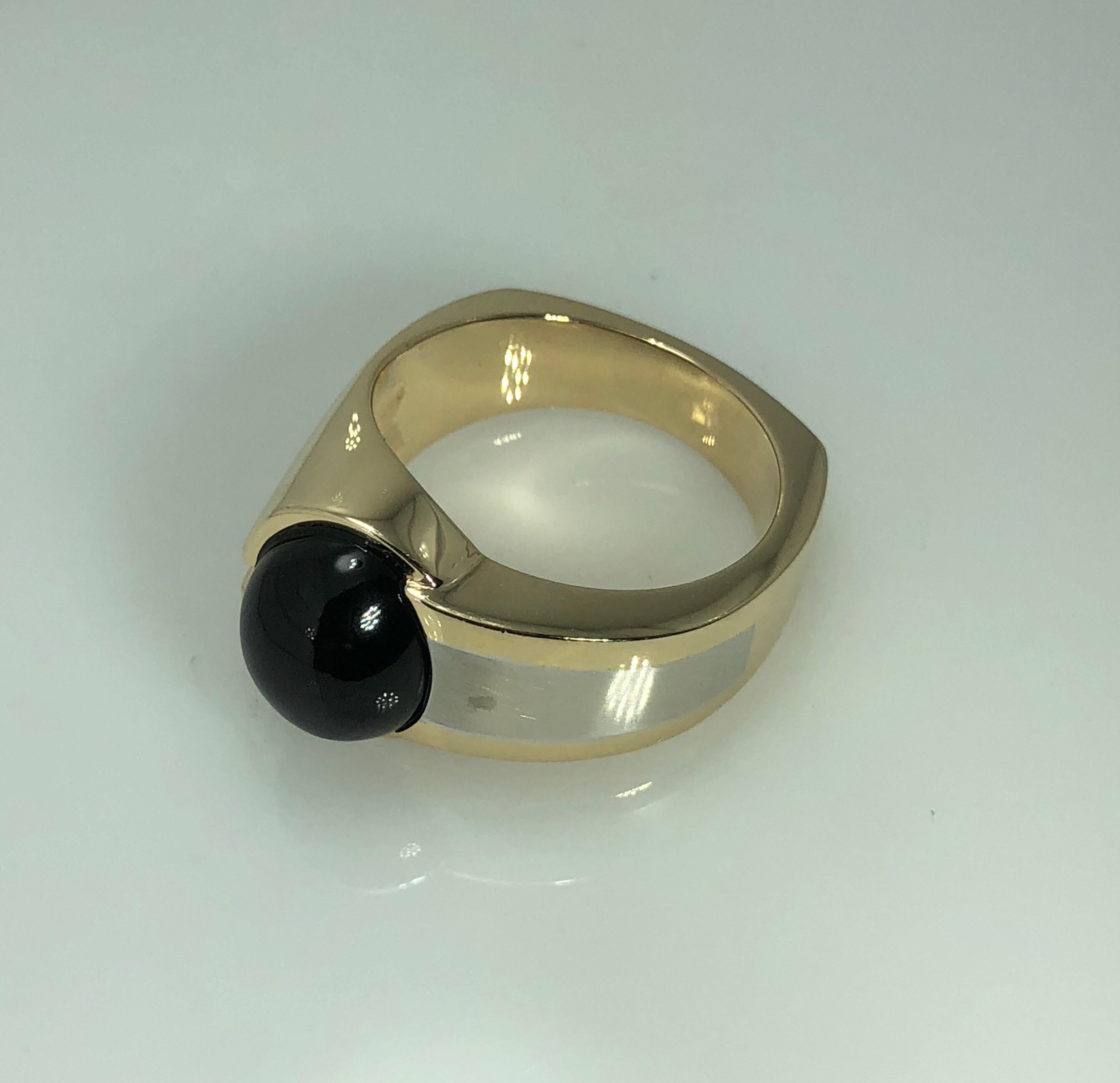 Mens 14 Karat white and Yellow Gold Onyx Contemporary Ring. This Mens ring is created in 14 karat white and yellow gold and weighs 17.3 grams. This piece is adorned with a cabochon cut oval 12mm by 10 mm black onyx. Finger size  This piece can be