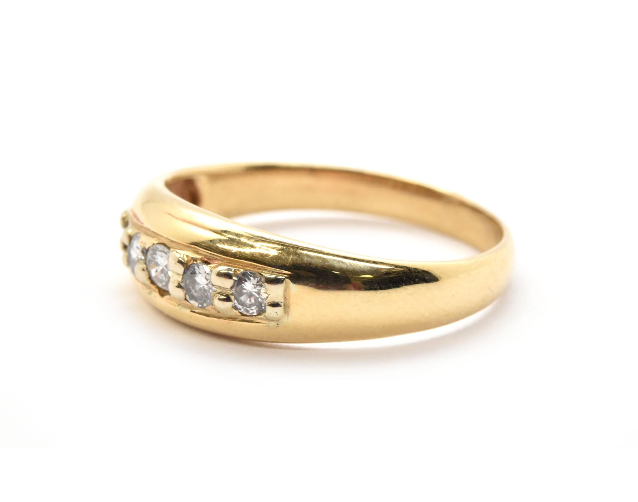 This men’s wedding band is crafted in 14 karat yellow gold and set with five round brilliant cut diamond melee down the center. The diamond total weight is 0.35Ctw with G-H color and SI1 clarity. It measures 6.6mm wide at the top, weighs 4.07 grams,