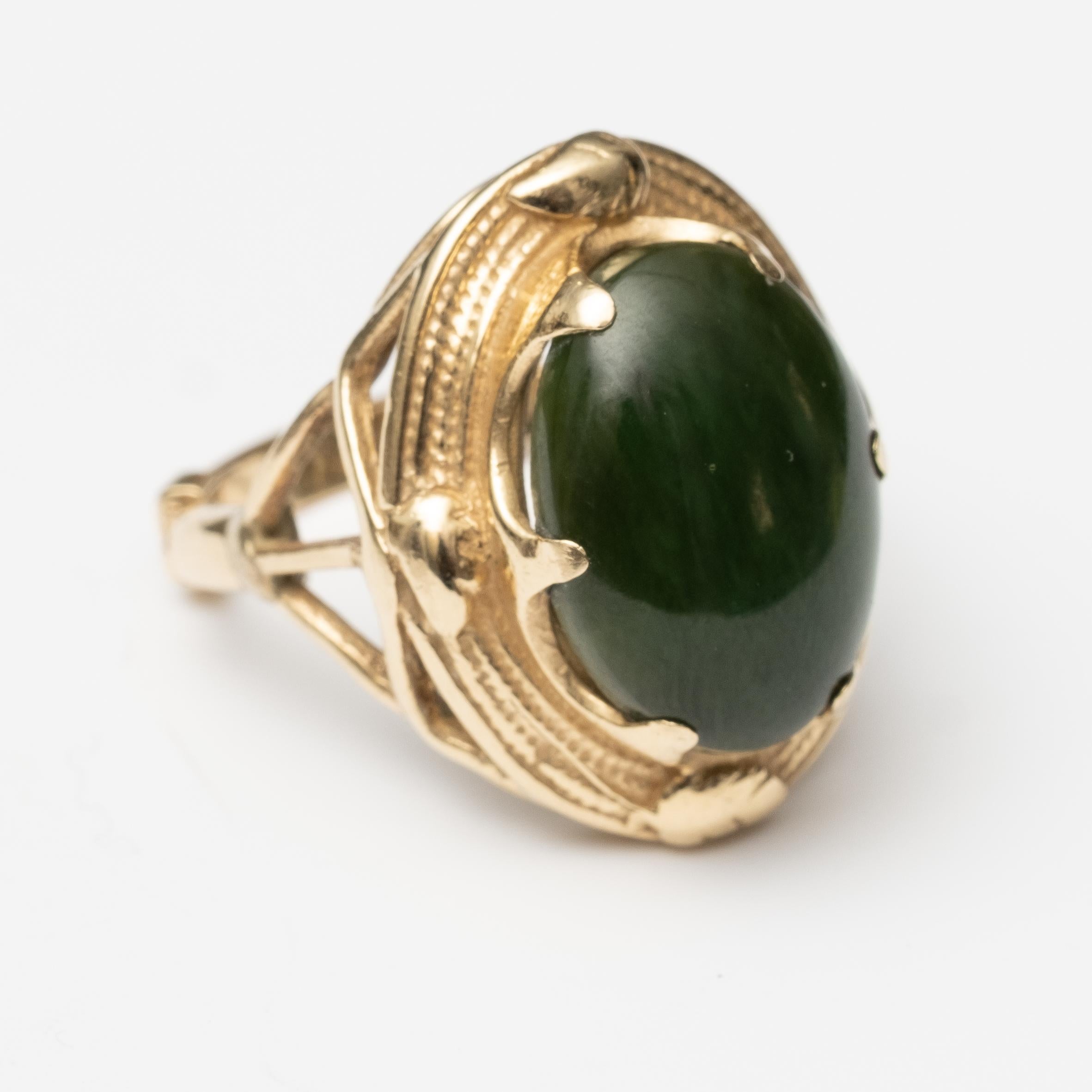Vintage Men's 14K Nephrite Jade Ring. The ring has an adjustable band. Band fully closed is a size 9.5. The ring weighs 10.35grams. Stone measure 17.6mm long. In good condition overall