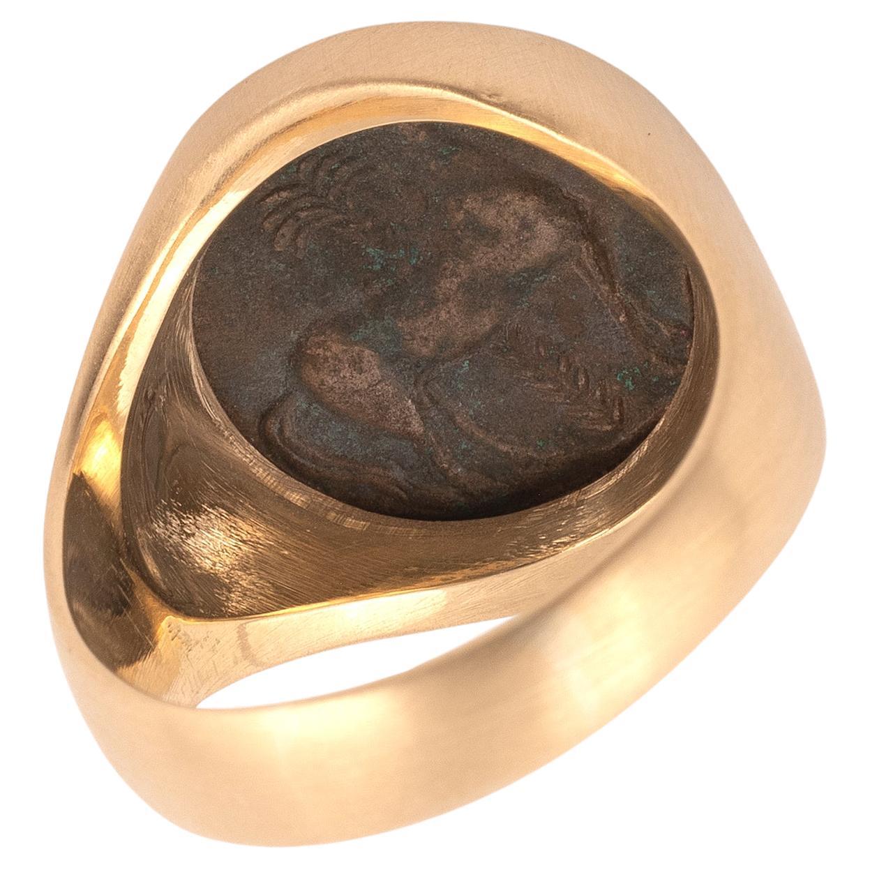 18kt yellow gold ring with hammered finish featuring ancient authentic Tanit coin center.
Size  9 3/4 but may be sized.
Weight: 13.73gr.

The Tanit ring exudes elegance with a captivating 20 mm bronze coin hailing from the esteemed Carthaginian