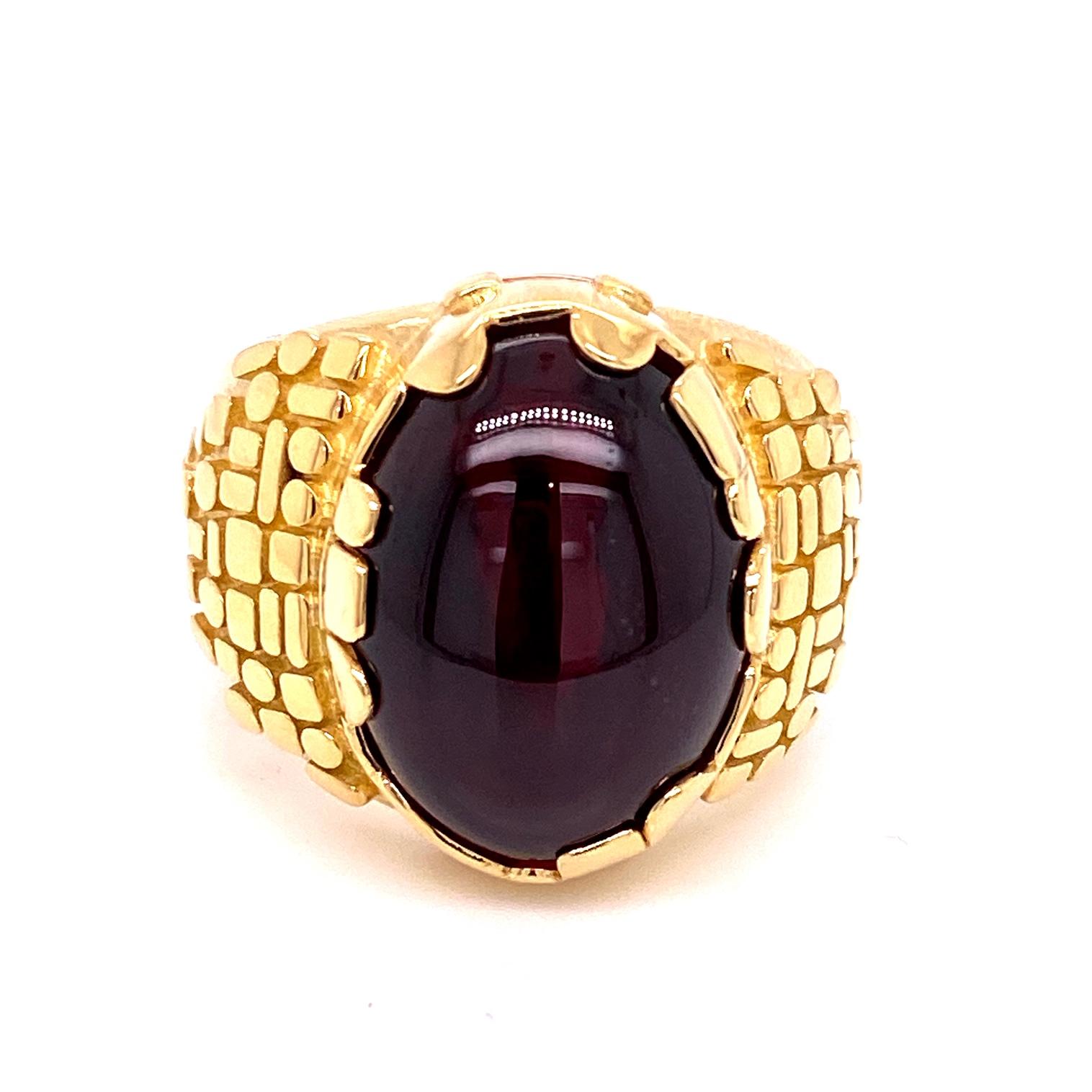 An 18k yellow and rose gold Men's ring set with one oval 12.84 carat carbunckle garnet ring (18mm x 13mm), ring size 10. This ring was made and designed by llyn strong.