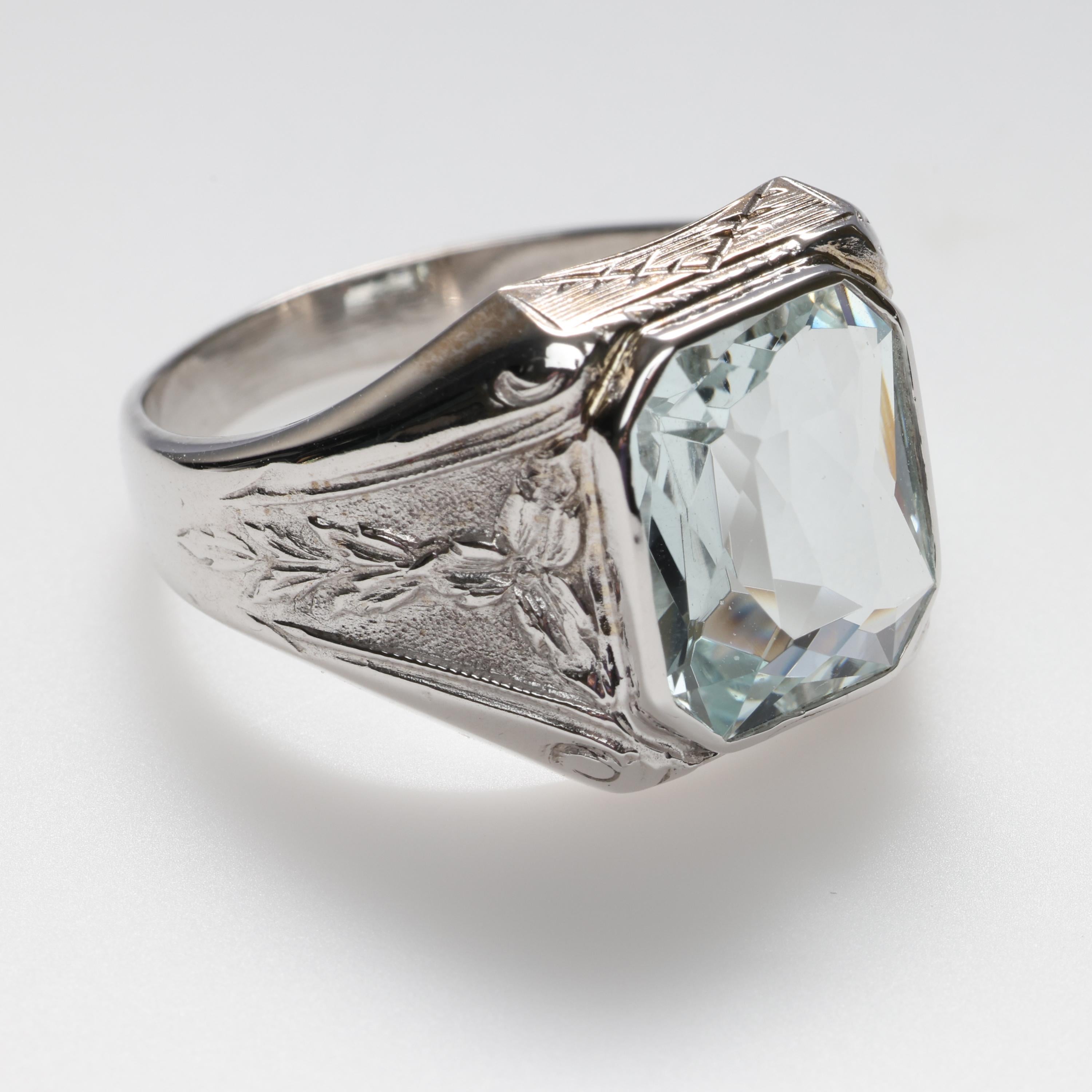 This classic, forever stylish men's ring was crafted in sturdy 10K white gold and features a 5 carat fancy rectangular-cut natural aquamarine gem. The 12.8 x 11mm natural gemstone is very pale blue and displays impressive flash and fire. But do not