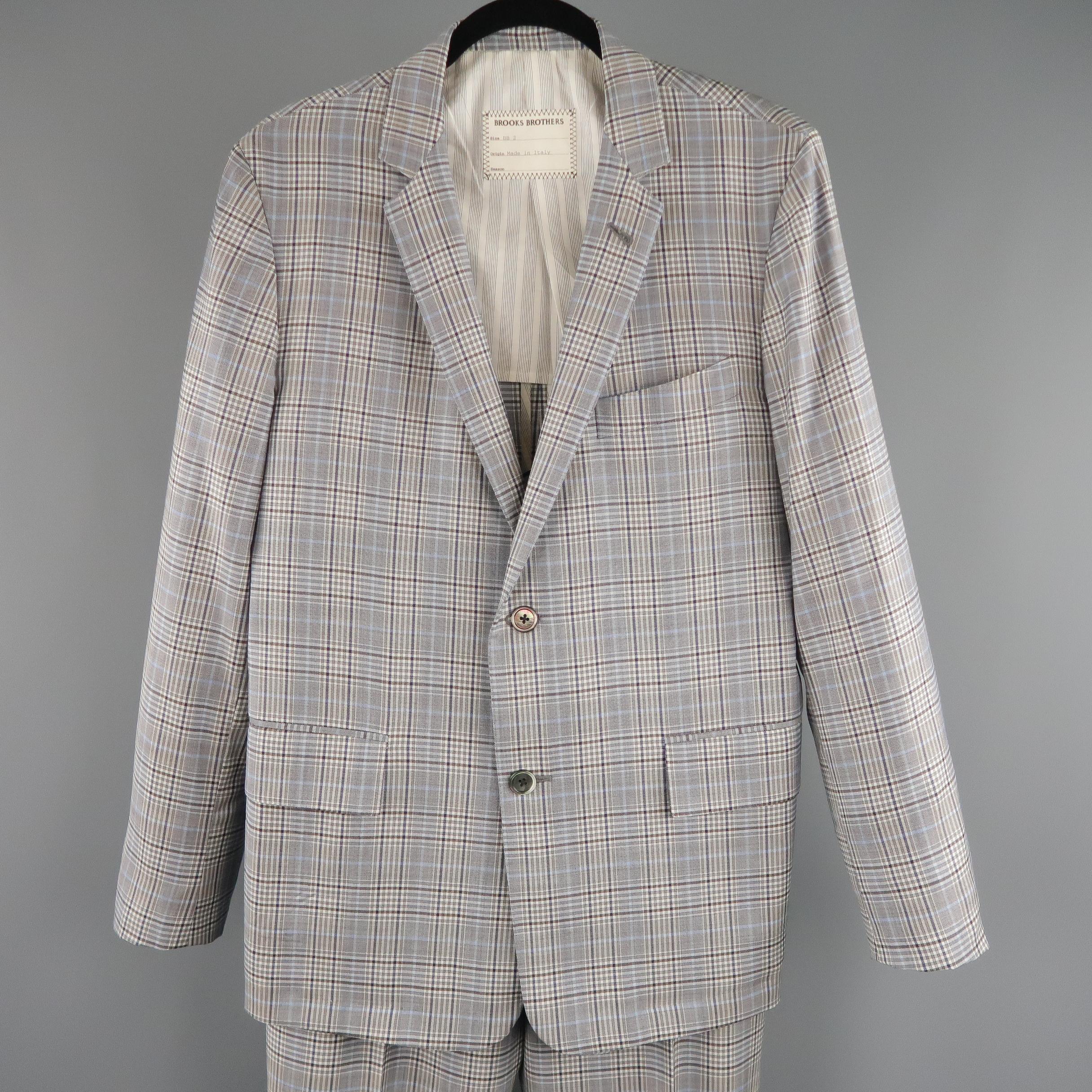 This two piece BROOKS BROTHERS suit comes in  gray and blue plaid wool blend fabric and includes a single breasted, two button sport coat with notch lapel, functional button cuffs,  and matching flat front, cuffed trousers. Made in Italy.
