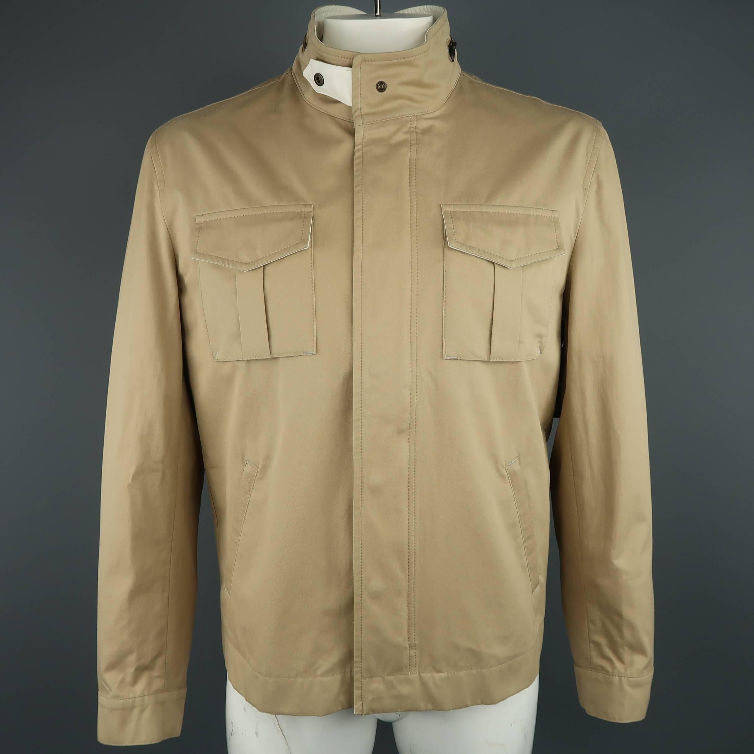BRUNELLO CUCINELLI jacket comes in khaki cotton twill and features a stand up collar with snap tab, hidden snap placket zip closure, patch flap military pockets, slanted side pockets, optional zip out hood, and snap cuffs. Made in Italy.
 
New with
