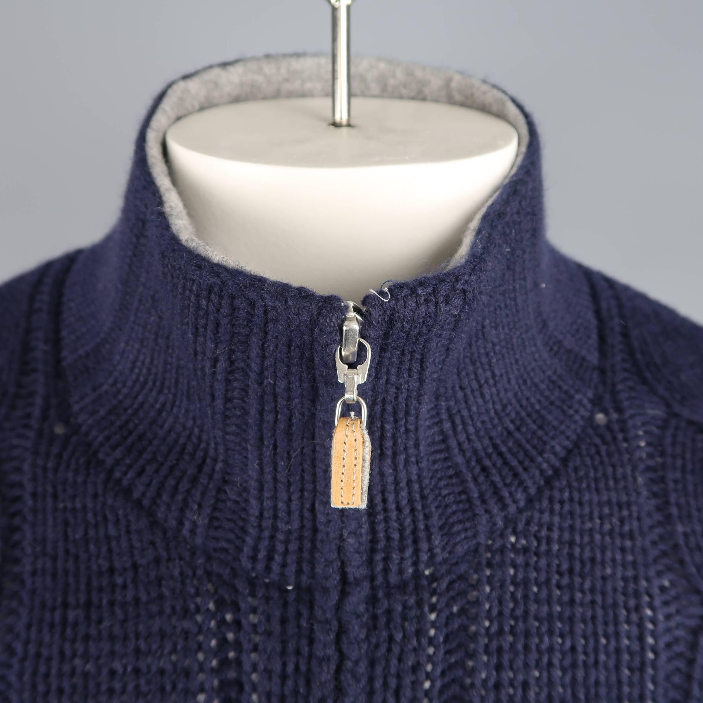 BRUNELLO CUCINELLI cardigan comes in wool, cashmere, and silk blend chunky cable knit with a high collar, hidden zip up front, and double zip pockets with tan leather tabs. Made in Italy.
 
Excellent Pre-Owned Condition.
Marked: IT 52
