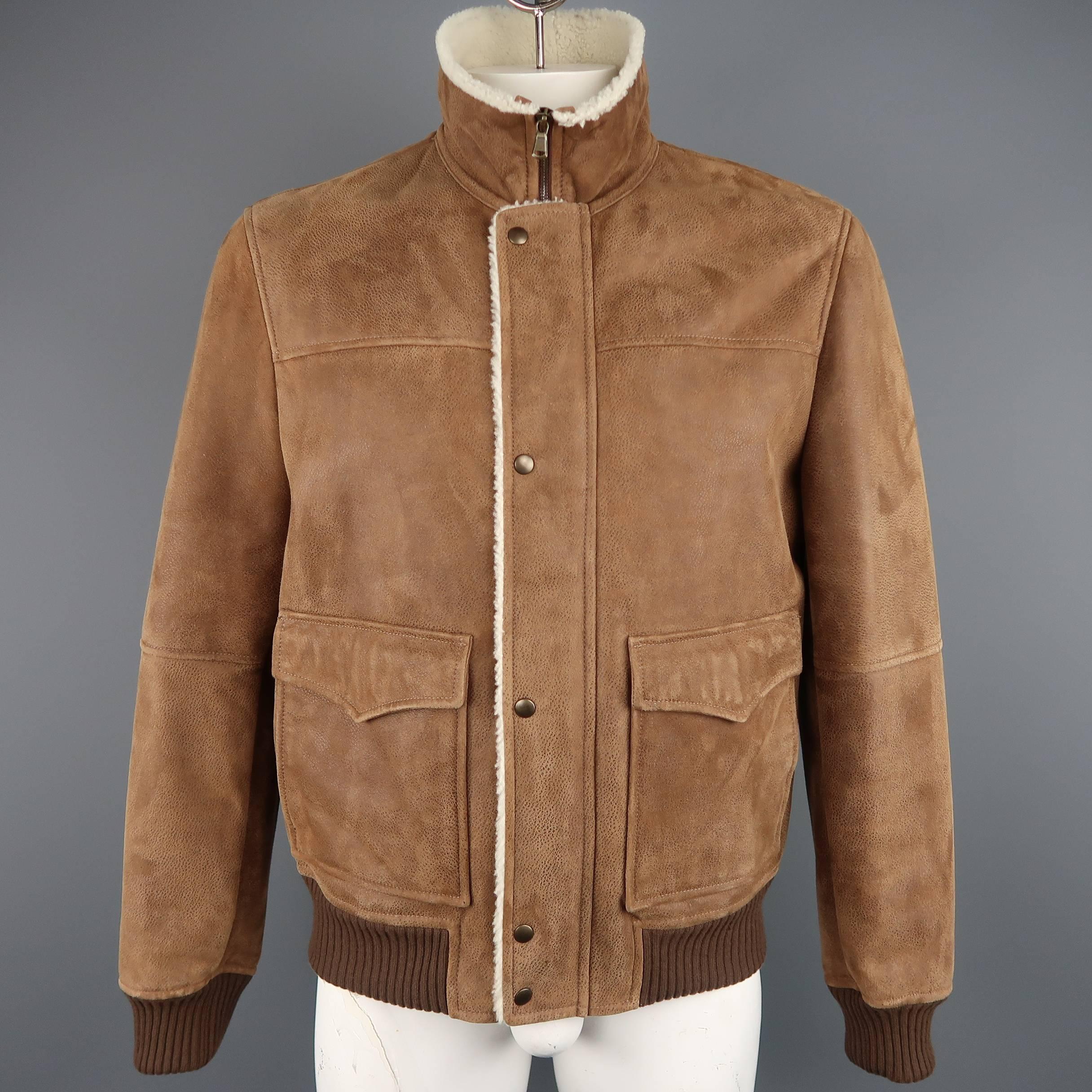 BRUNELLO CUCINELLI bomber jacket comes in tan spotted, cream fur interior  shearling with a high collar, zip closure with hidden snap placket, patch flap pockets, and brown ribbed knit waistband and cuffs. Made in Italy.
 
Excellent Pre-Owned
