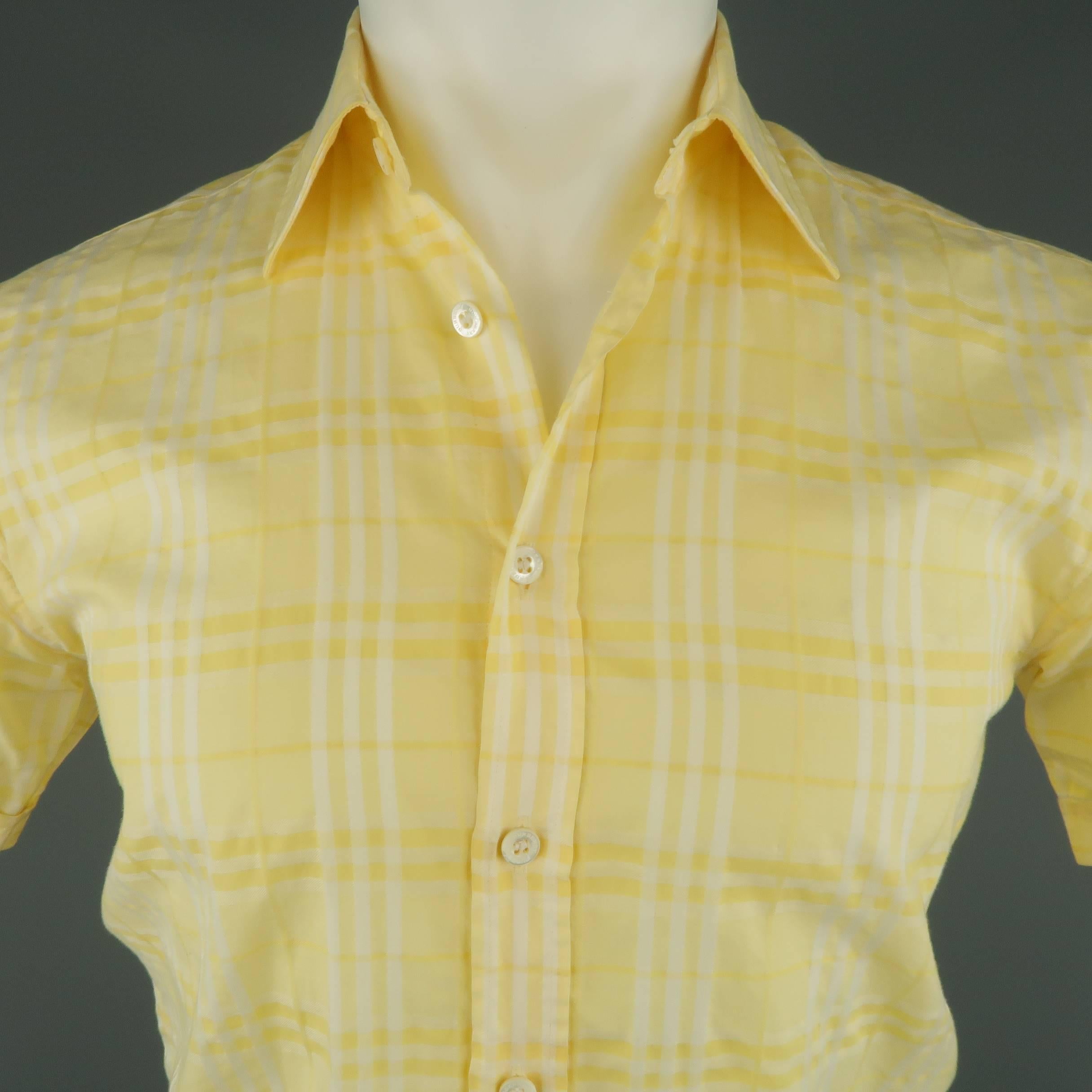 BURBERRY LONDON cotton button up shirt features classic Burberry plaid print in various faint hues of yellow.
 
Good Pre-Owned Condition.
Marked: XS
 
Measurements:
 
Shoulder: 17.5 in.
Chest: 40 in.
Sleeve: 8 in.
Length: 30 in.
