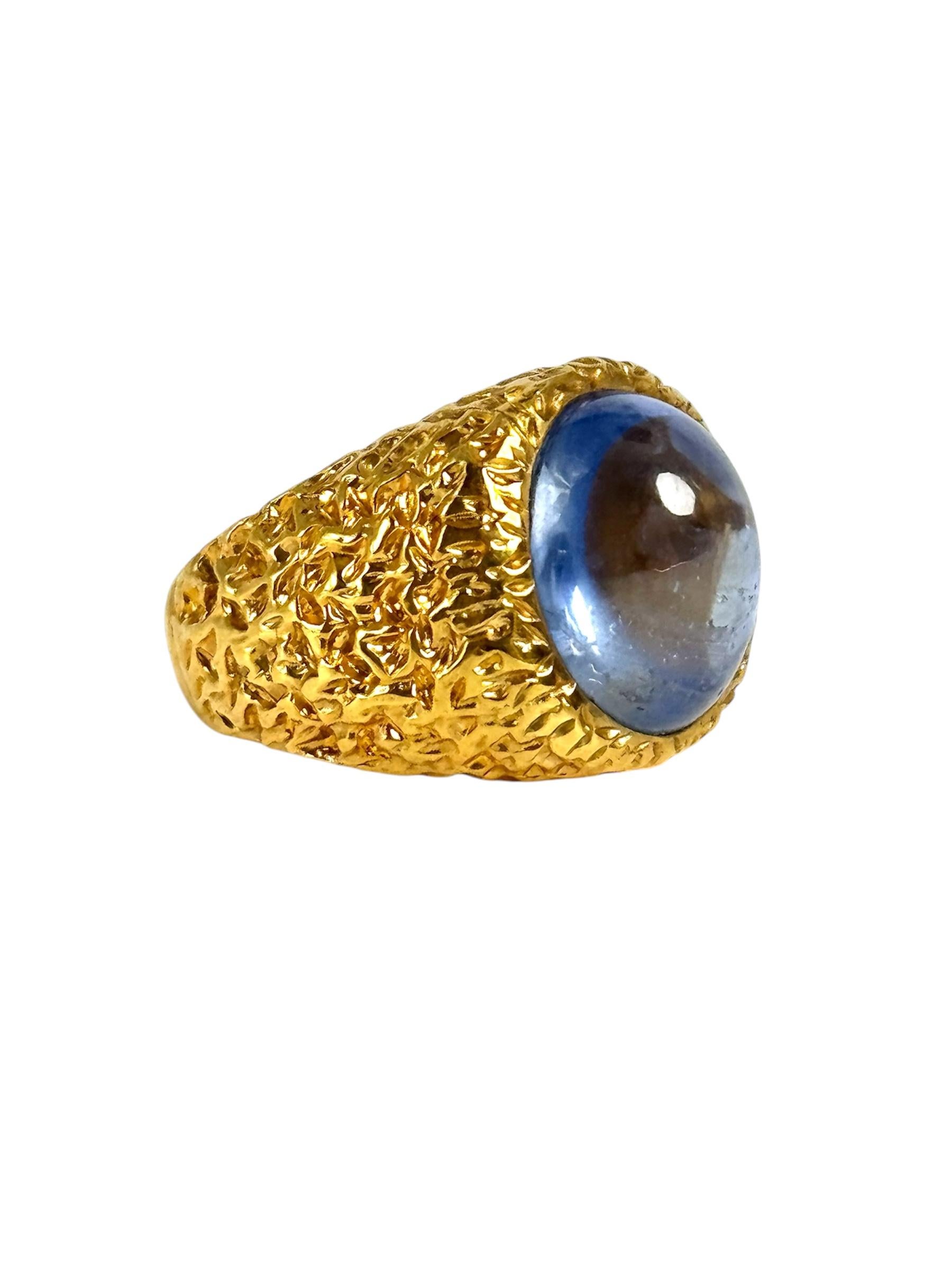This exquisite ring highlights the unique beauty of a substantial 13.44 carat cabochon sapphire, set in rich 14K yellow gold. The cabochon cut, with its polished, unfaceted dome, allows the sapphire's natural depth and subtle internal