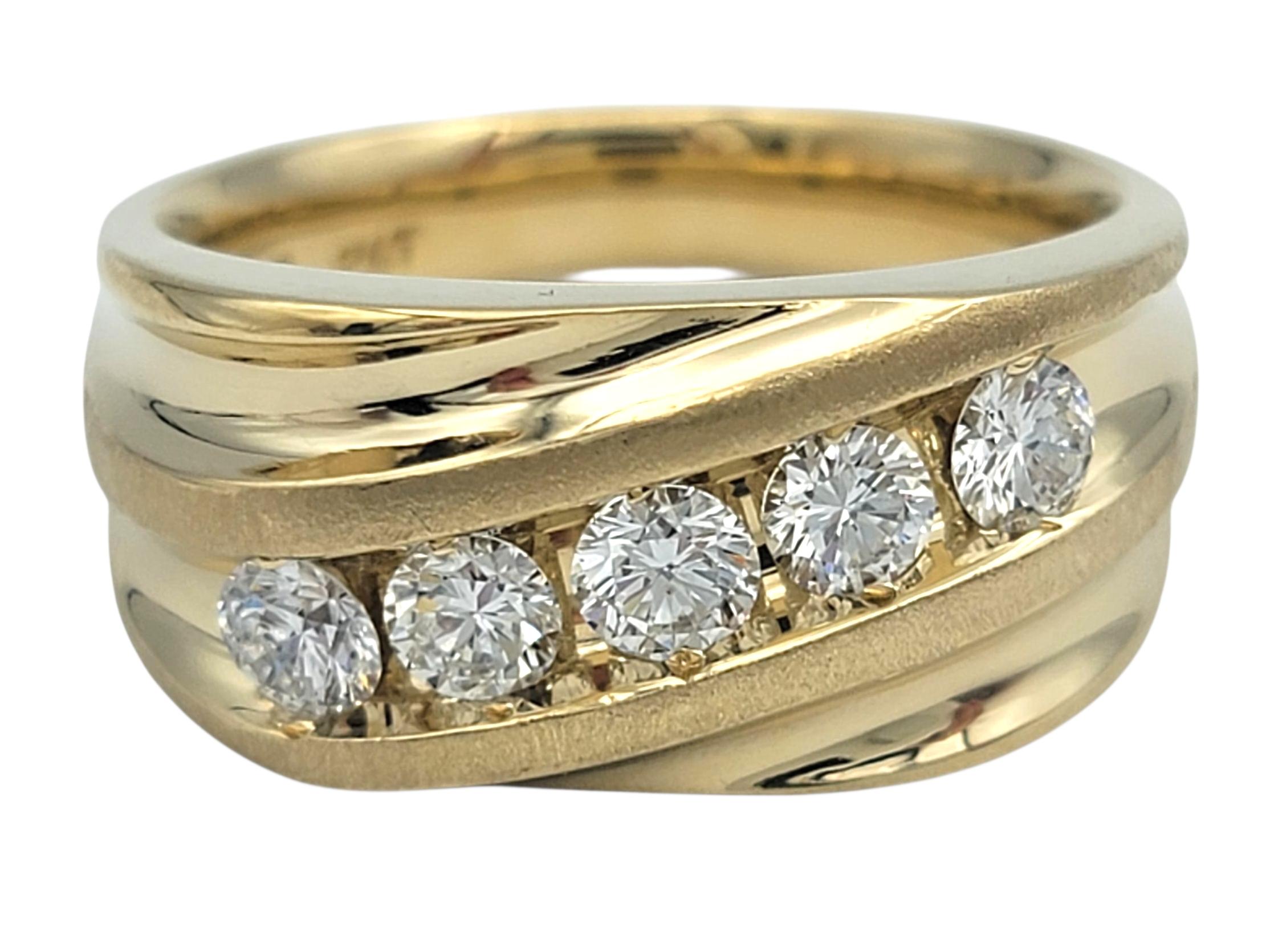 This striking mens diamond ring blends timeless brilliance with modern sculptural design. Crafted in warm 14 karat yellow gold, the band features a wave-like pattern that sweeps gracefully across the finger. Nestled within the flowing gold lines are