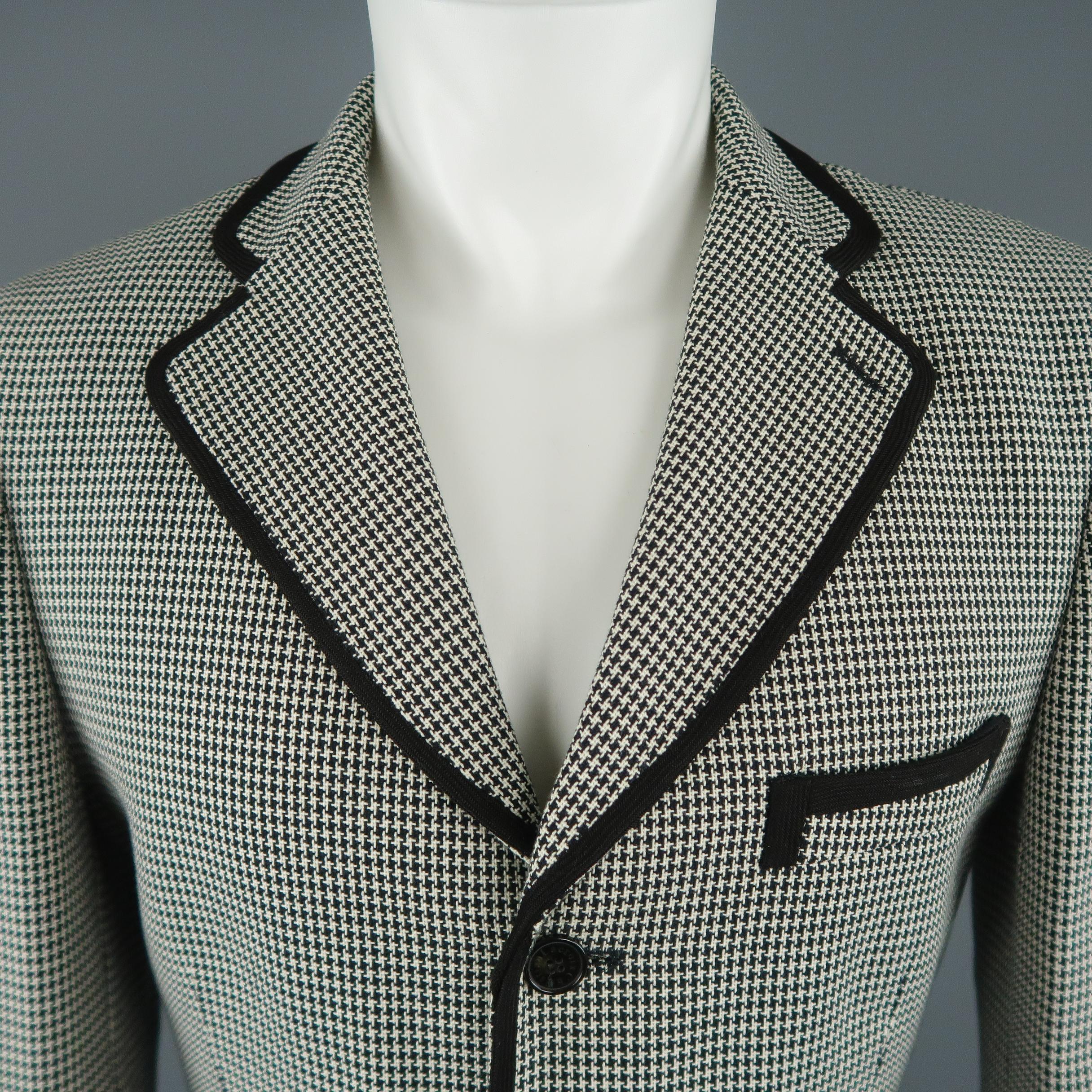 Vintage CHRISTIAN LACROIX HOMME sport jacket comes in black and white houndstooth fabric with a notch lapel, single breasted three button front, flap pockets, thick knit piping, and graphic liner. Made in France.
 
Excellent Pre-Owned