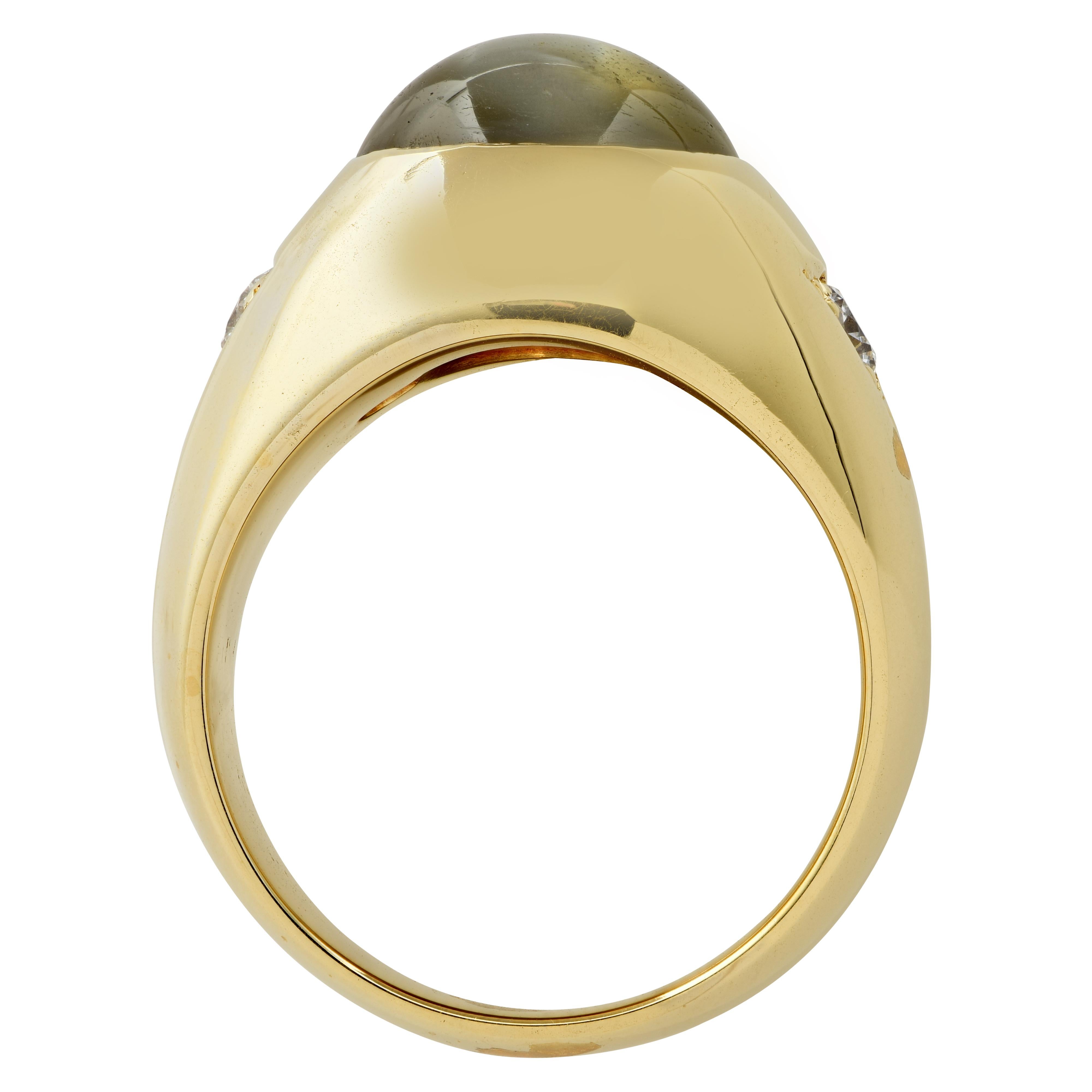Men’s pinkie ring crafted in 18 karat yellow gold showcasing a spectacular chrysoberyl cat’s eye cabochon weighing approximately 8 carats, accompanied by two round brilliant cut diamonds weighing approximately .30 carats total, G color, VS clarity.