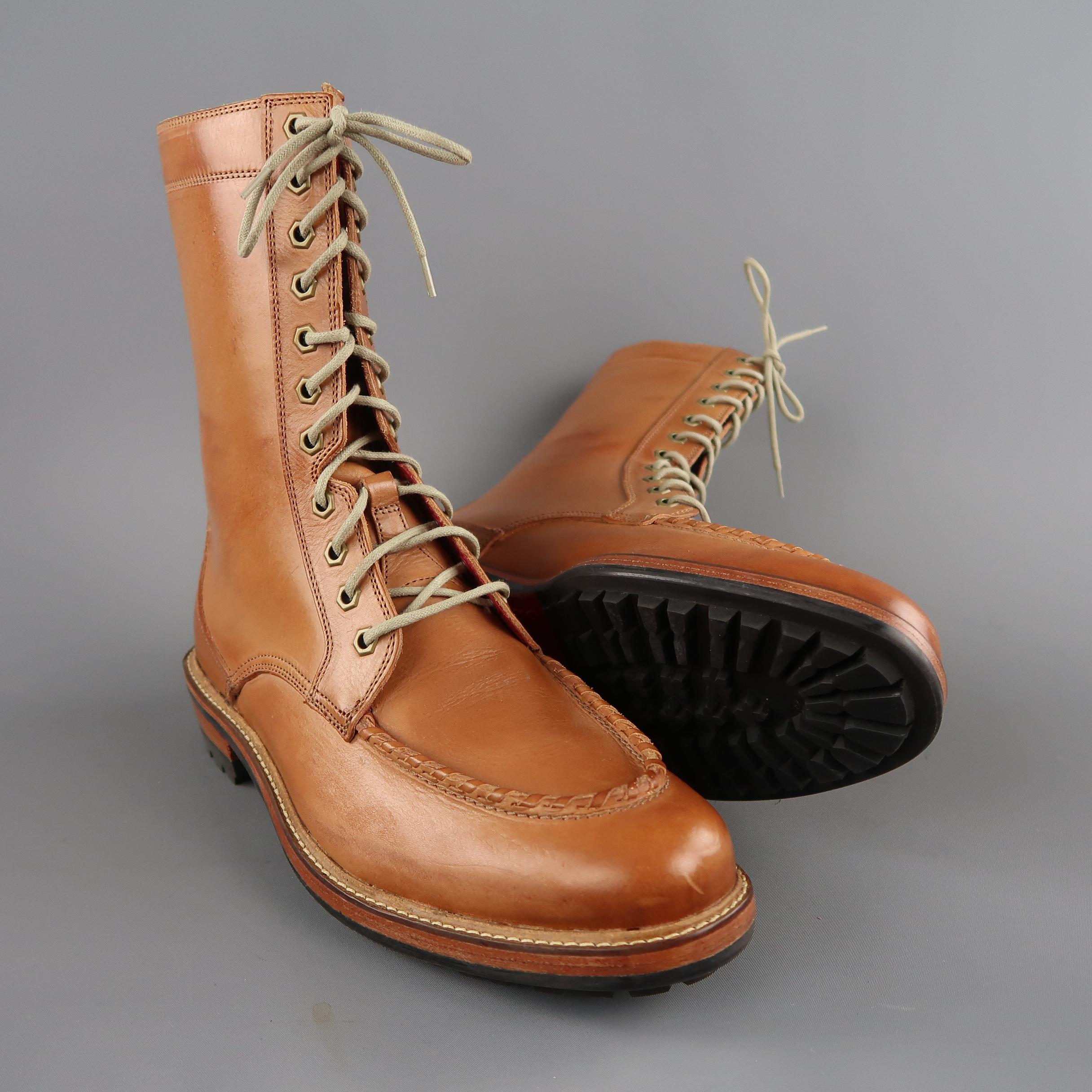 Tall over ankle length mid calf boots come in tan leather with a whip stitched apron toe, lace up front with antique gold tone grommets, and stacked, heeled sole.
 
Brand New.
Marked:10.5 M
 
Measurements:
 
Length: 9.5 in.
Outsole: 12 x 4.5 in.