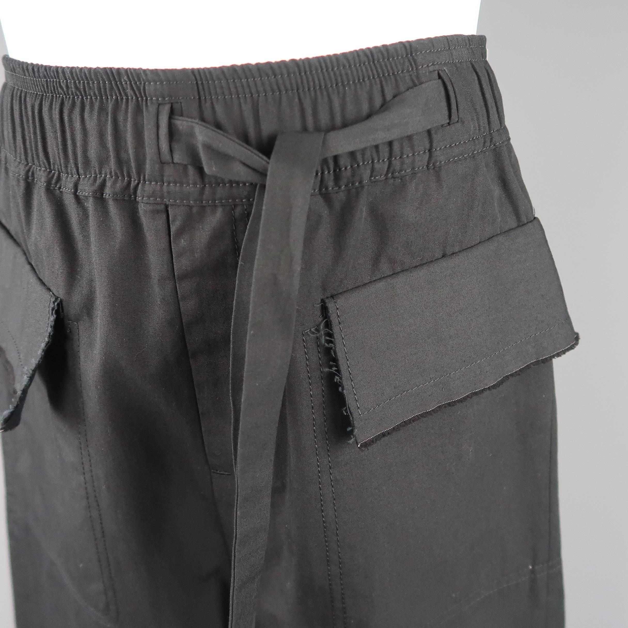 DAMIR DOMA shorts come in black cotton with an elastic waist band, asymmetrical tie, flap pockets with raw edge trim, and drop crotch panel. Made in Italy.
 
New with Tags.
Marked: S
 
Measurements:
 
Waist: 30 in.
Rise: 19 in.
Inseam: 11 in.
 

