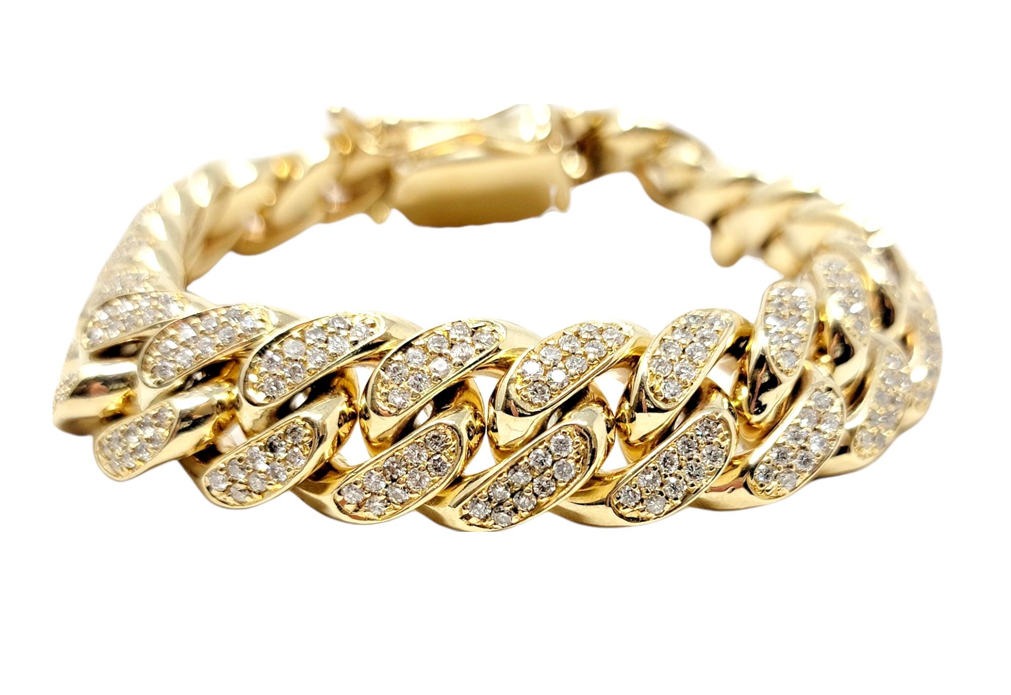 Bold, heavy men's diamond link bracelet. This incredibly handsome piece features a polished 10 karat yellow gold Cuban link design set in a repeating pattern throughout. The solid gold links are chunky in shape and stand out beautifully on the