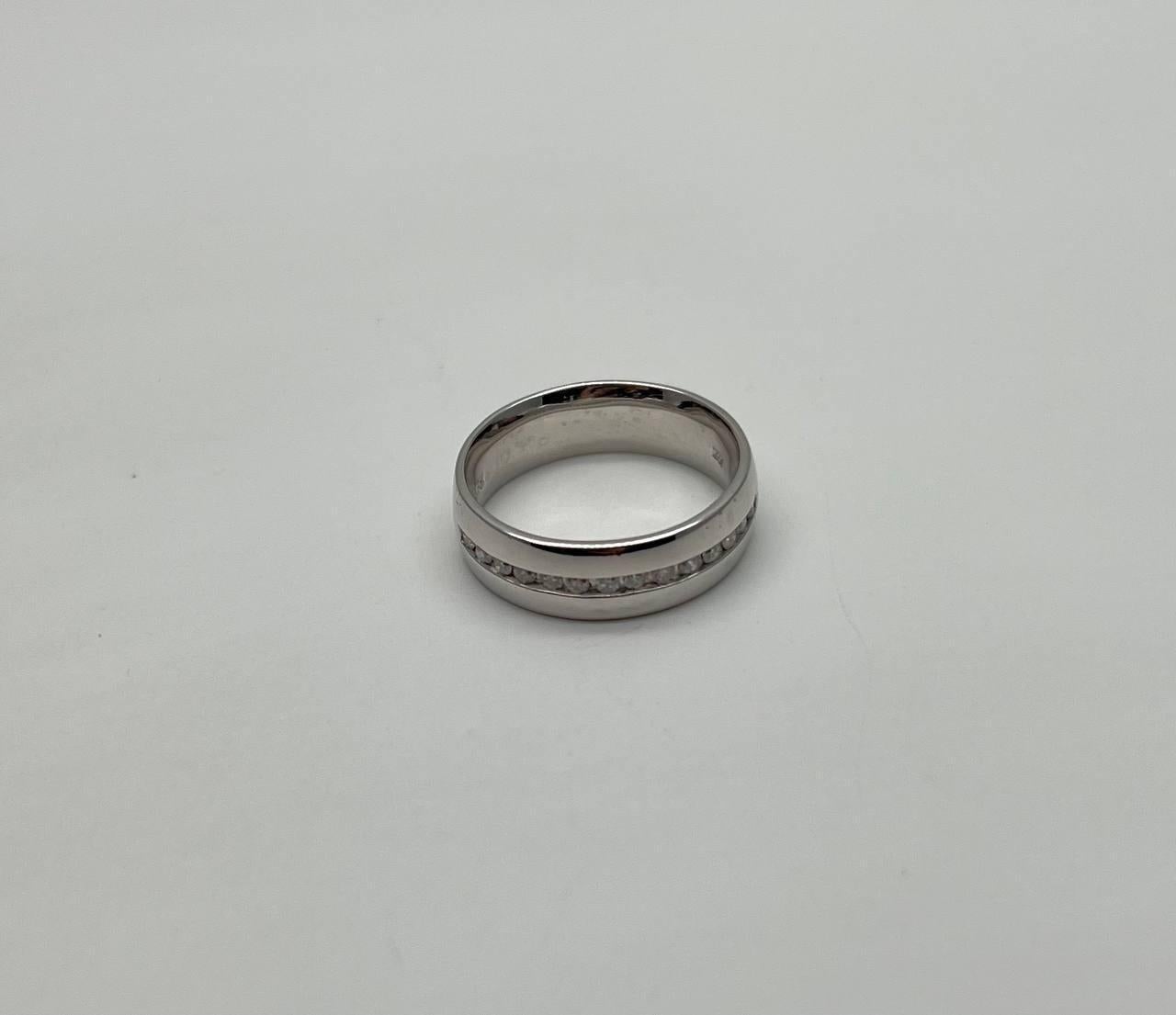 This elegant ring is crafted in a sleek 14k white gold band. It features a central channel of classic, sparkling diamondsset in a linear pattern. The band has a smooth, polished finish, enhancing its modern appeal.
0.35 CTW Diamonds 
14K White Gold